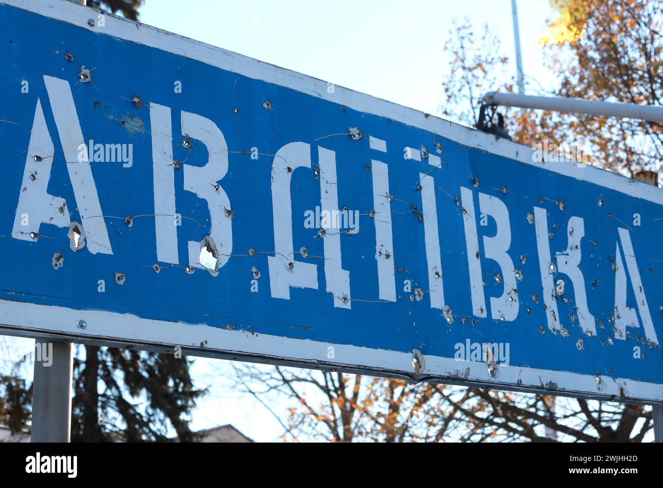 Straßenschild mit Inschrift auf Ukrainisch - Avdiiwka, Donezk, von Kugeln gebrochen. Ukrainischer Krieg. Ukraine Russland Krieg, Zerstörung, Avdeevka Stockfoto