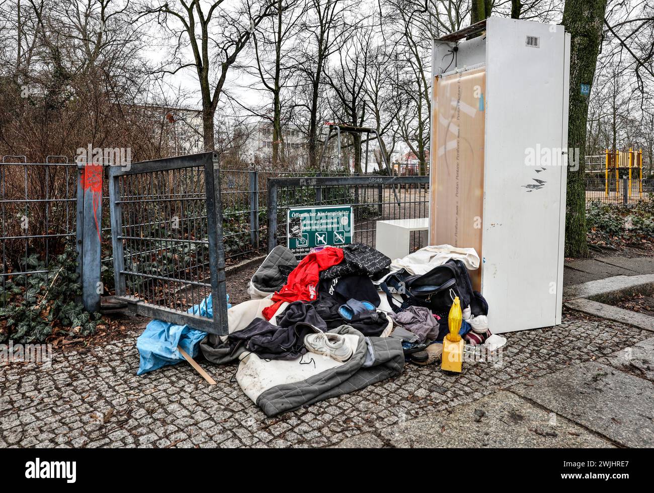 Kleidung, eine Warnleuchte und ein Kühlschrank blockieren den Eingang zu einem öffentlichen Spielplatz, illegale Abfallentsorgung im Berliner Stadtteil Wedding Stockfoto