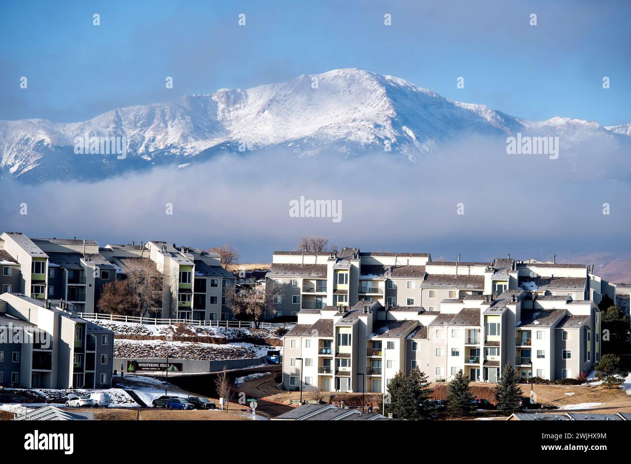 Ein Wintersturm zieht sich über den Pikes Peak in Colorado Springs. Apartments, Stadthäuser und Eigentumswohnungen in den Ausläufern bieten einen wunderschönen Blick auf die Berge. Stockfoto