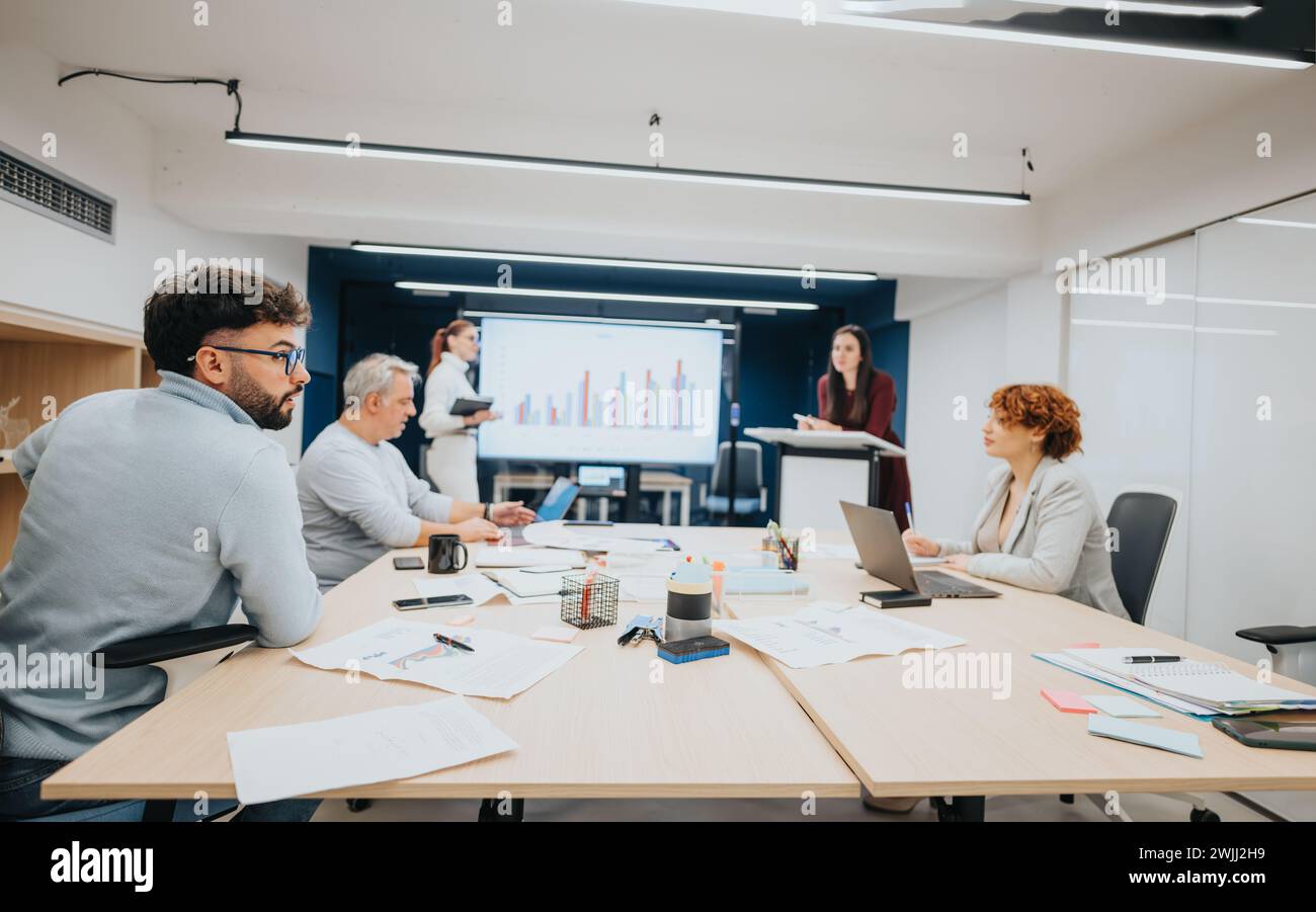 Geschäftsleute, die in einem Klassenzimmer an einem Workshop für strategisches Management zusammenarbeiten. Stockfoto