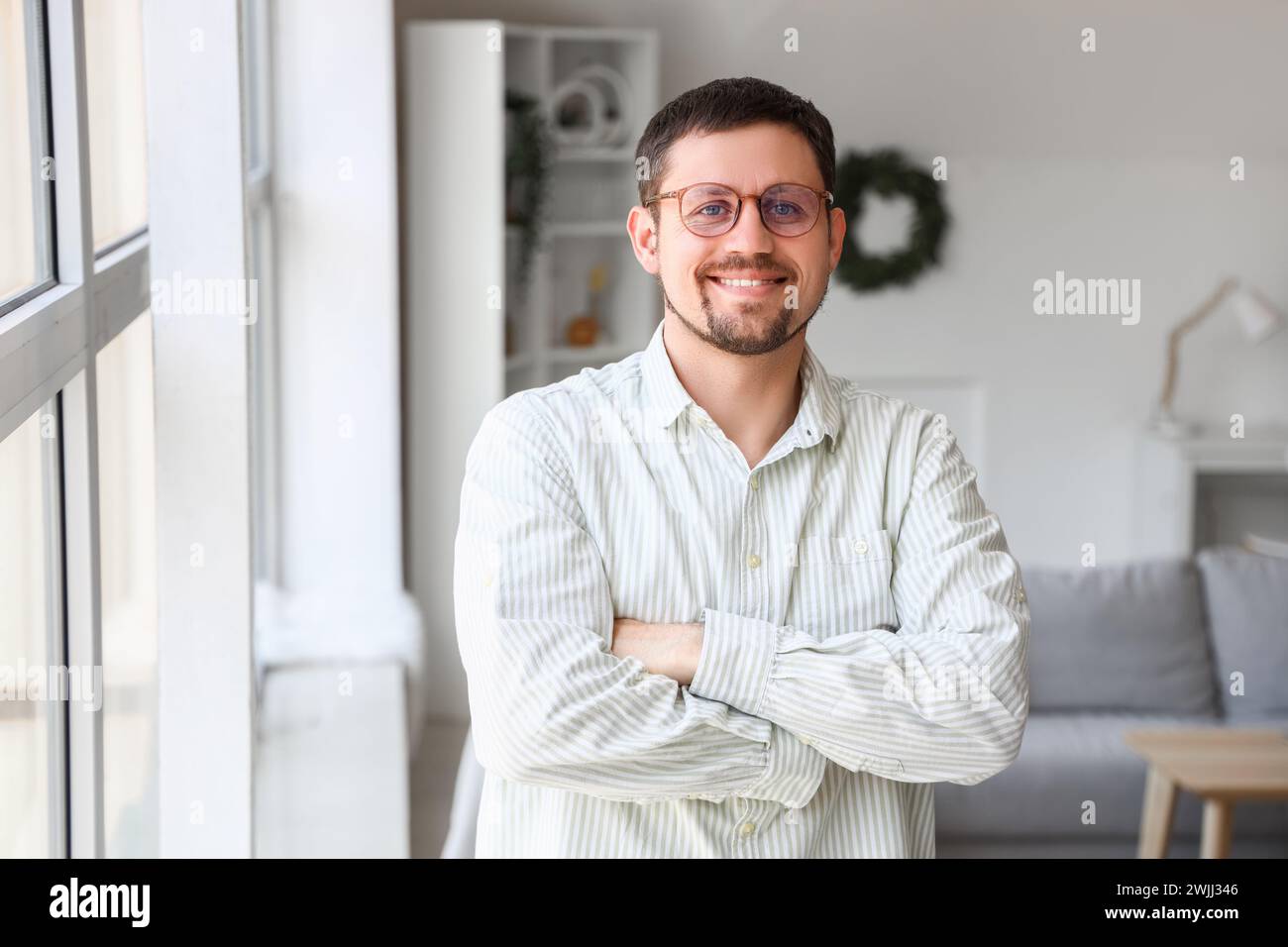Schöner Mann in stilvoller Brille zu Hause Stockfoto