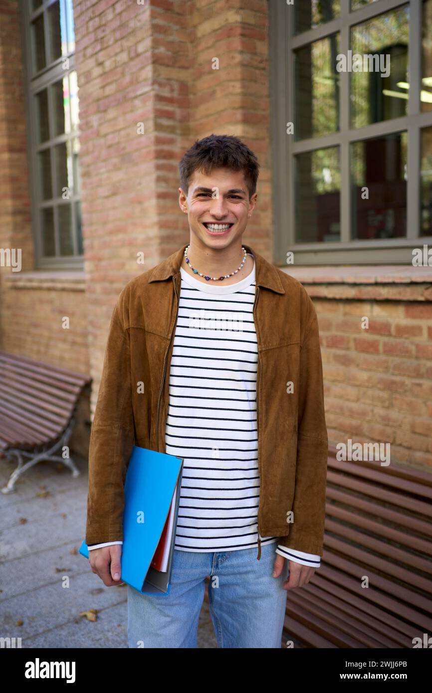 Vertikales Porträt eines glücklichen jungen europäischen Mannes, ein glückliches lächelndes Gesicht auf der Straße. Männliche Menschen fröhlich. Stockfoto