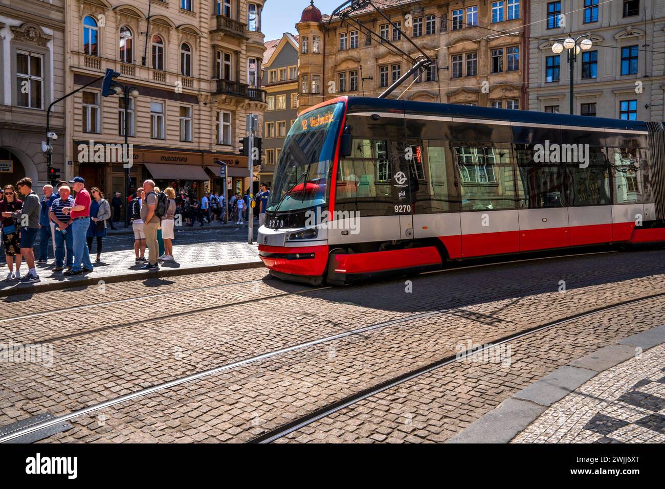 Prag, Böhmen – CZ – 3. Juni 2023 Blick auf die Menschenmenge, die an der geschäftigen Straßenbahnhaltestelle Malostranské náměstí in Mala Strana oder weniger auf die Straßenbahn Nr. 12 wartet Stockfoto