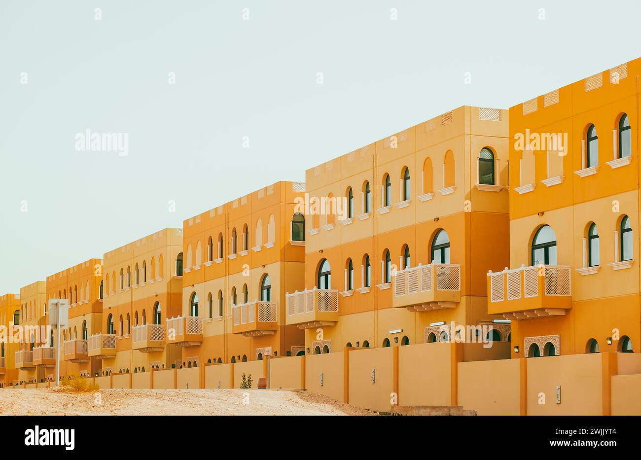 Villenanlage an einem hellen sonnigen Tag. Wohnhaus mit Apartments und Balkonen im arabischen Stil. Niemand, Straßenfoto Stockfoto