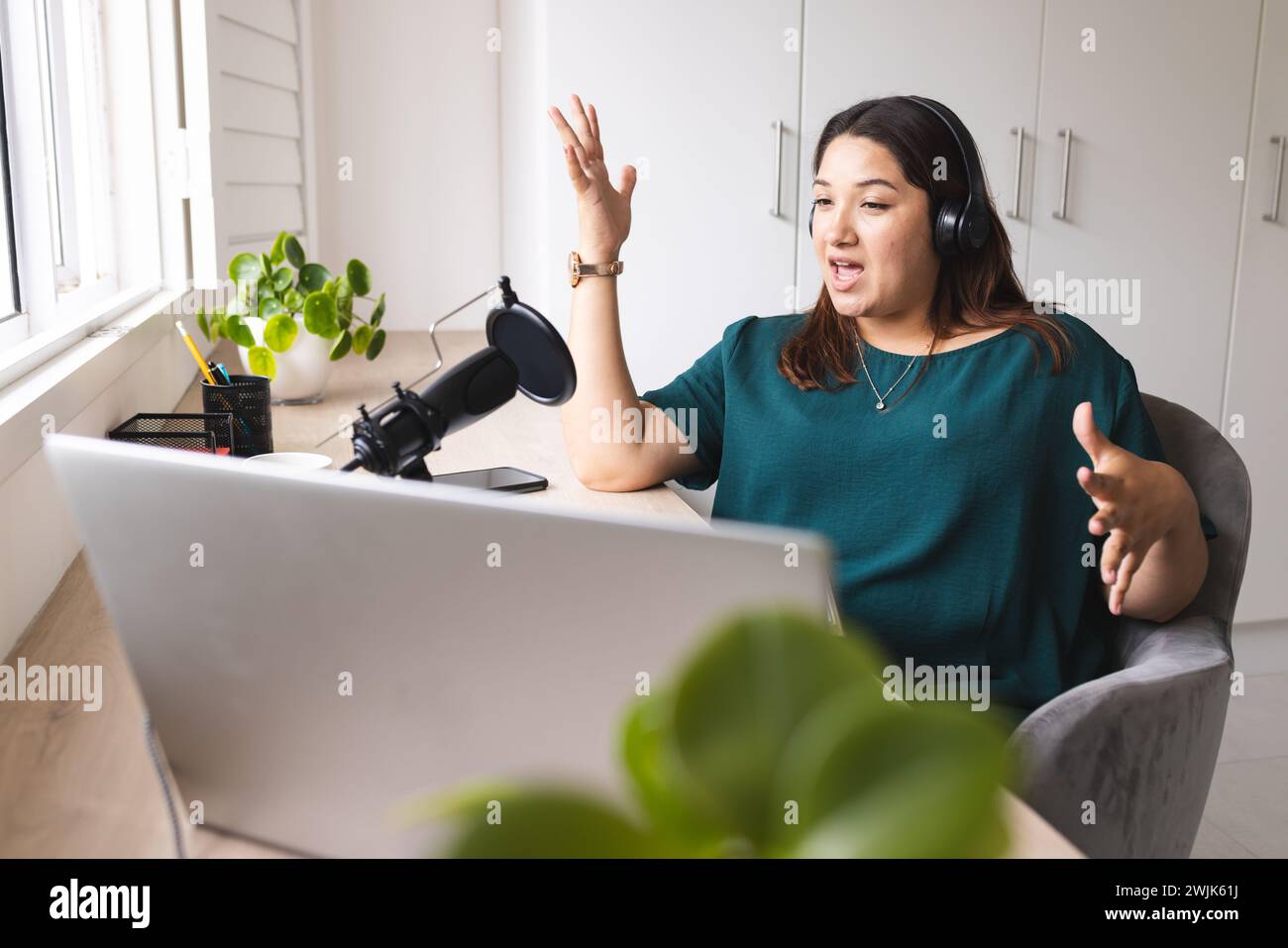 Die junge Frau nimmt einen Podcast von zu Hause auf Stockfoto