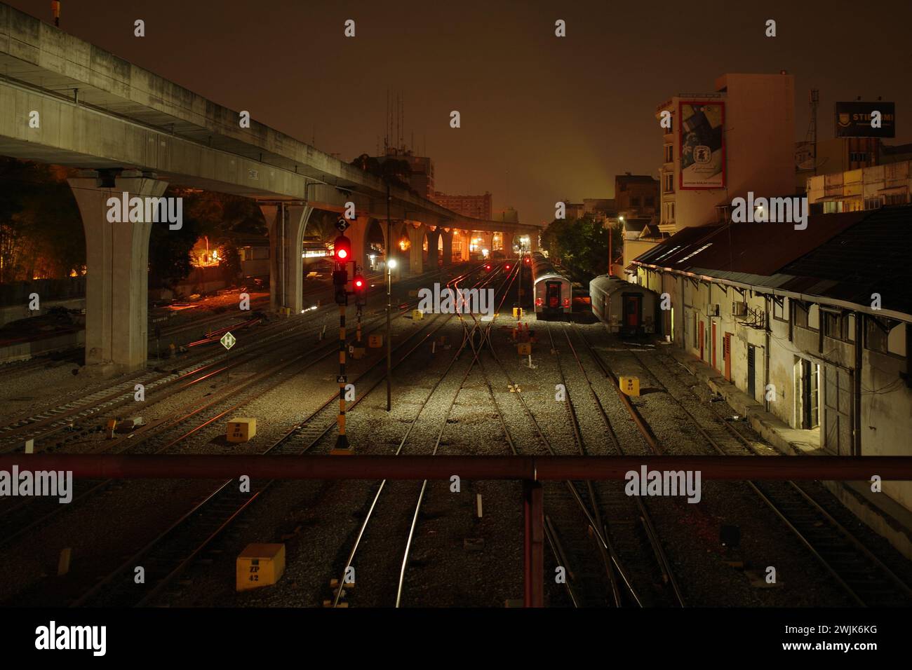 Unter dem Schleier der Nacht durchquert der Zug der Stadt Medan die Dunkelheit, seine Lichter malen Lichtstreifen, ein nächtliches Spektakel. Stockfoto