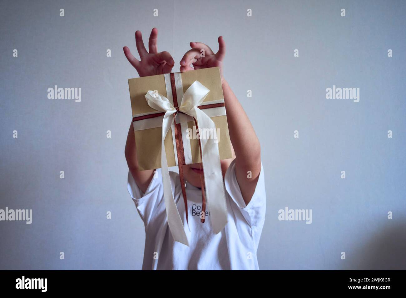 Ein kleiner Junge hält einen Geschenkgutschein in der Hand Stockfoto