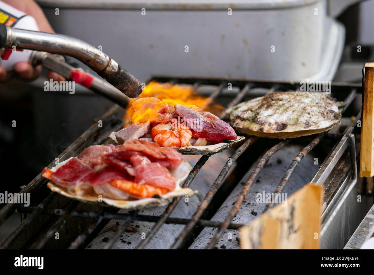 Kochen Sie Meeresfrüchte an einem Imbissstand auf dem Tsukiji Outer Market in Tokio, Japan. Stockfoto