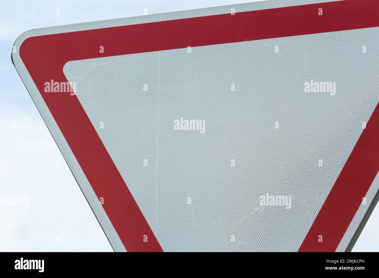 Straßenschild am Himmel. Weißes Dreieck mit rotem Rand. Signal, Platz machen. Sommertag. Stockfoto