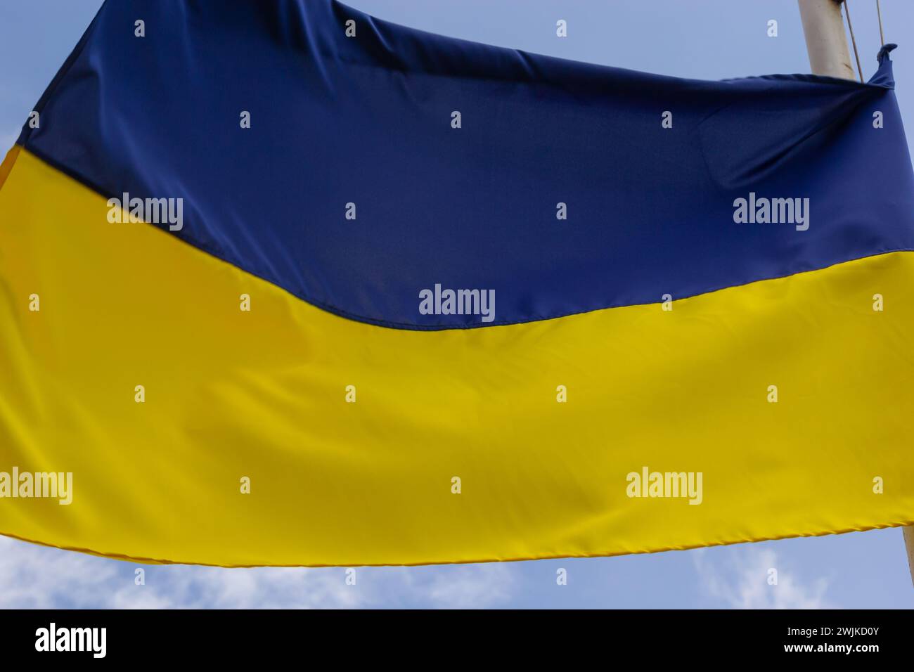Ukrainische Flagge winkt bei Wind und Sonnenlicht. Flagge der Ukraine auf blauem Himmel Hintergrund. Nationales Symbol für Freiheit und Unabhängigkeit. Stockfoto