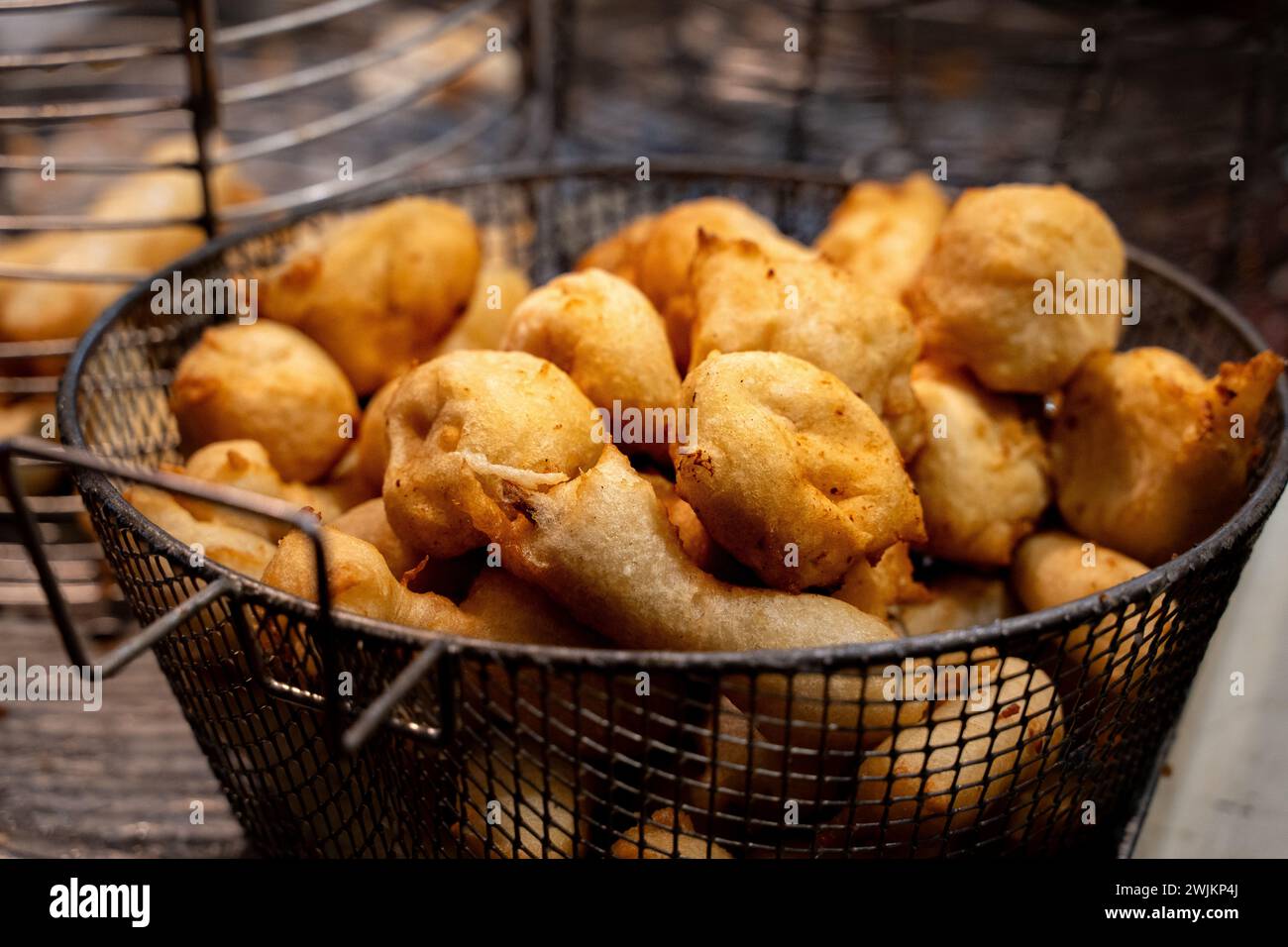 Goldene Sardellen in einem Korb - Street Food Delikatesse in der Nacht. Stockfoto