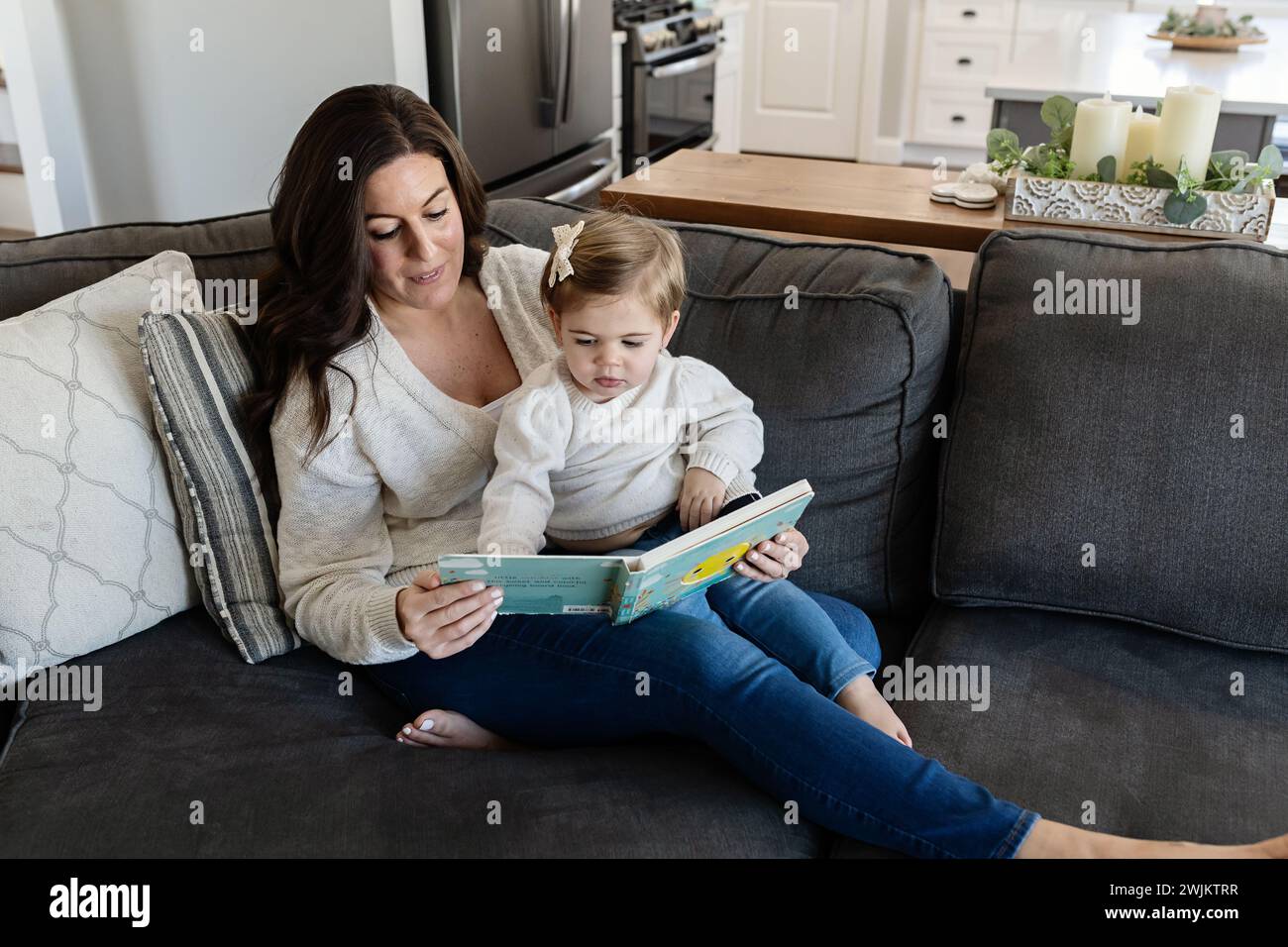 Mutter und Tochter lesen auf der Couch Stockfoto