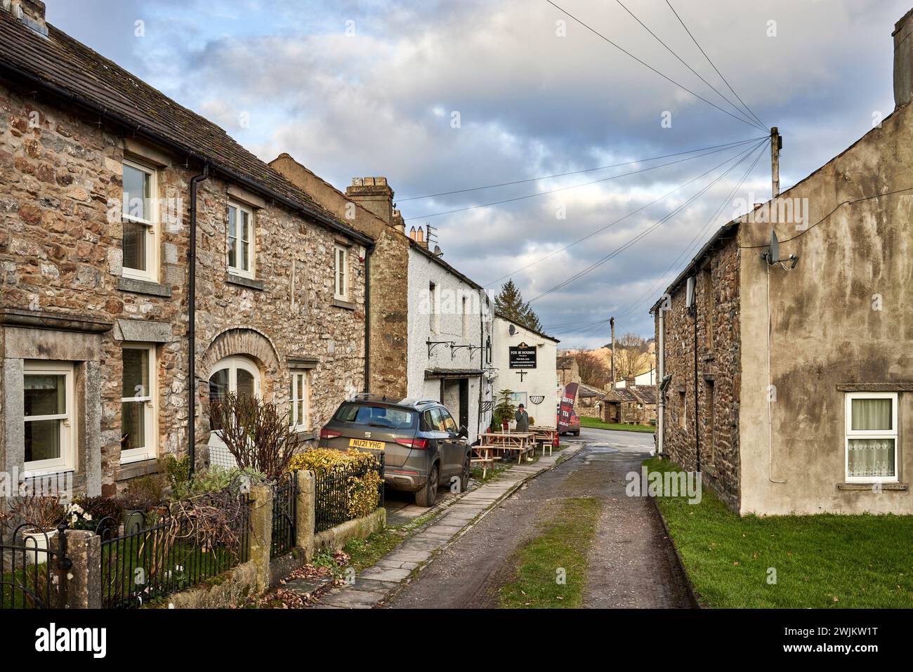 Zentrum von West Burton mit einer Hintergasse, die zu einer Reihe gut gepflegter Cottages und dem Fox & Hounds Pub führt. Stockfoto