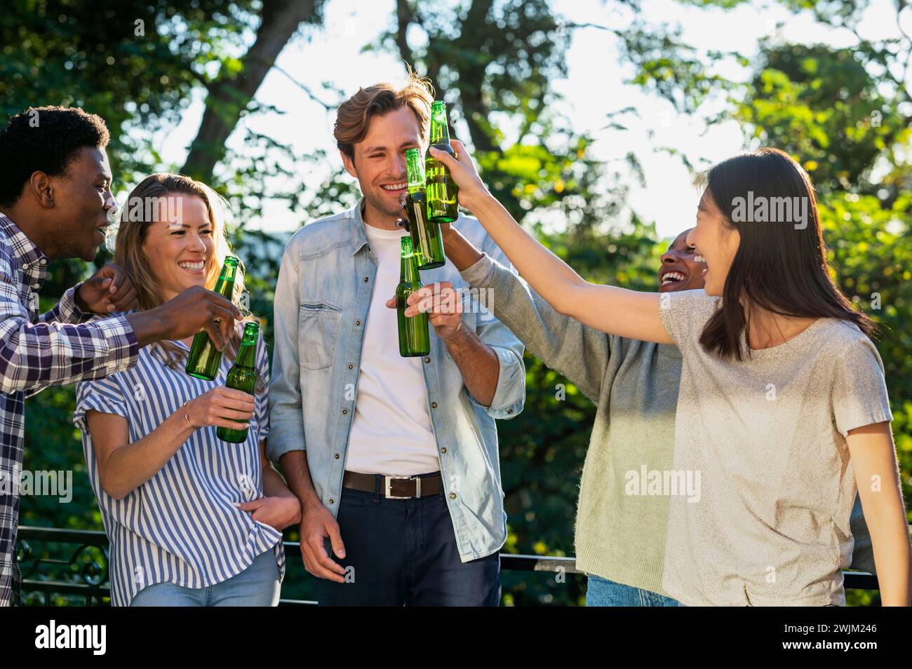 Gruppe von Freunden, die im Freien mit Bierflaschen tosten Stockfoto
