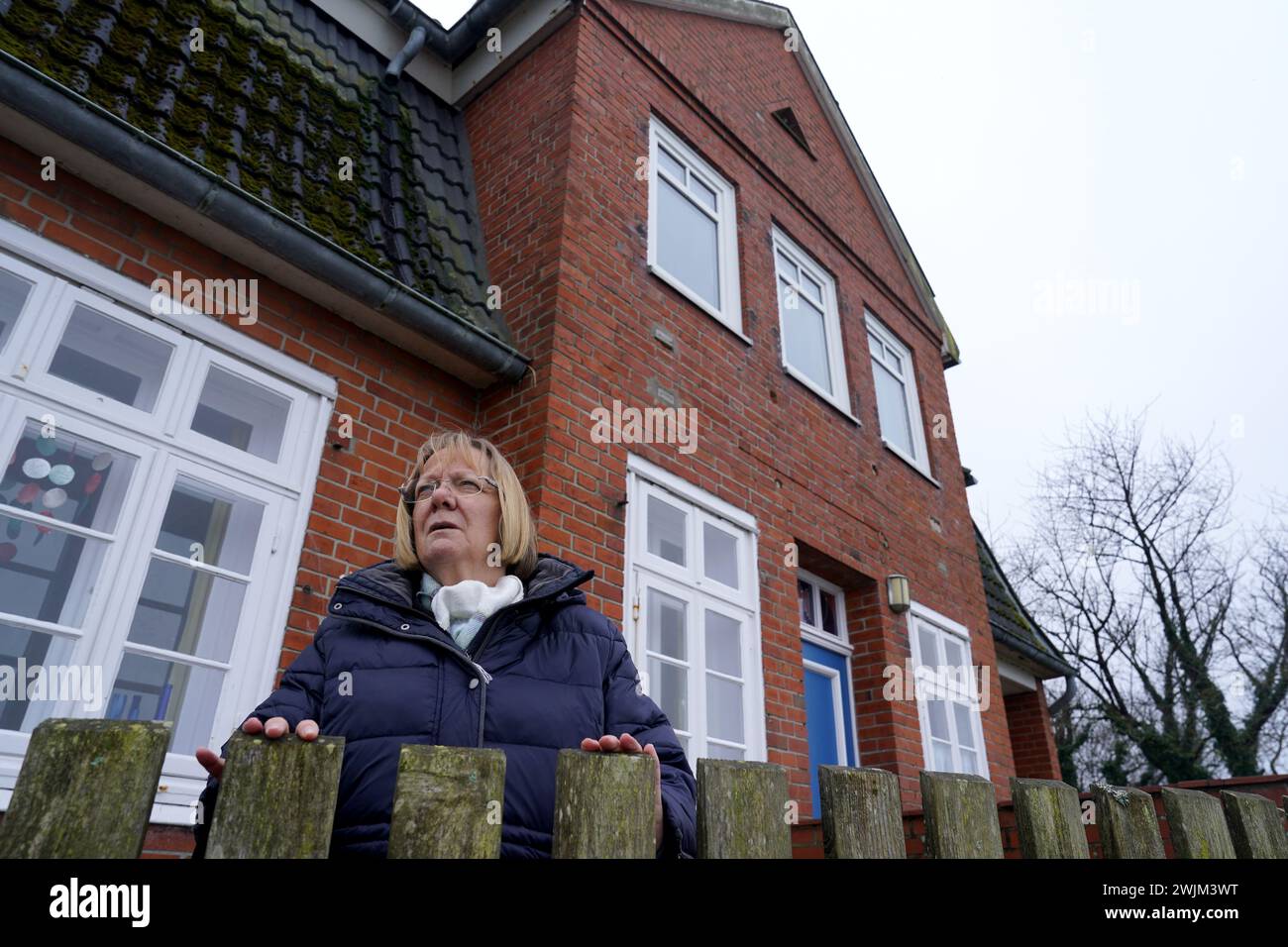 PRODUKTION - 14. Februar 2024, Schleswig-Holstein, Lübeck-Travemünde: Renate Paulien-Wittmaack, Bezirksvorsitzende der Jugendorganisation SJD - die Falken, steht vor dem Jugendzentrum "Haus Seeblick" im Brodten-Bezirk an der Ostsee. Das Jugendzentrum Haus Seeblick, direkt an den Brodtenfelsen gelegen, ist nach einem weiteren Randabbruch für Kinder- und Jugendarbeit geschlossen. Nur gut vier Meter liegen zwischen einer Ecke des 'Haus Seeblick' und dem Abgrund. Ende Januar fiel ein Baum entlang des Randes und hinterließ ein Loch im Fußweg vor dem Haus. Foto: Marc Stockfoto