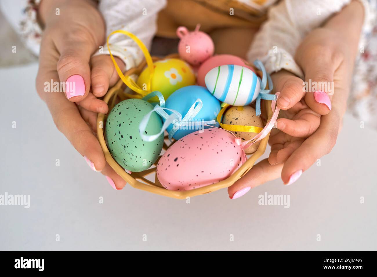 Selektiver Fokus auf mehrfarbigen Eizellen und Design Ostereier auf der Hand, Family Easter Concept Stockfoto