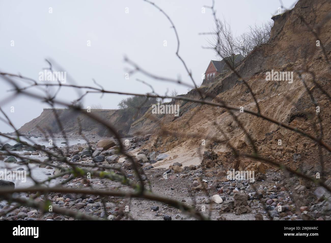 PRODUKTION - 14. Februar 2024, Schleswig-Holstein, Lübeck-Travemünde: Blick auf die gebrochene Klippe im Jugendzentrum Haus Seeblick der Jugendorganisation SJD - die Falken, auf der Klippe im Stadtteil Brodten an der Ostsee. Das direkt an den Brodtenfelsen gelegene Jugendzentrum Haus Seeblick ist nach einer weiteren Randabbruch nun für Kinder- und Jugendarbeit geschlossen. Nur gut vier Meter liegen zwischen einer Ecke des 'Haus Seeblick' und dem Abgrund. Ende Januar fiel ein Baum entlang des Randes und hinterließ ein Loch im Fußweg vor dem Haus. Foto: Marcus Brandt/dpa Stockfoto