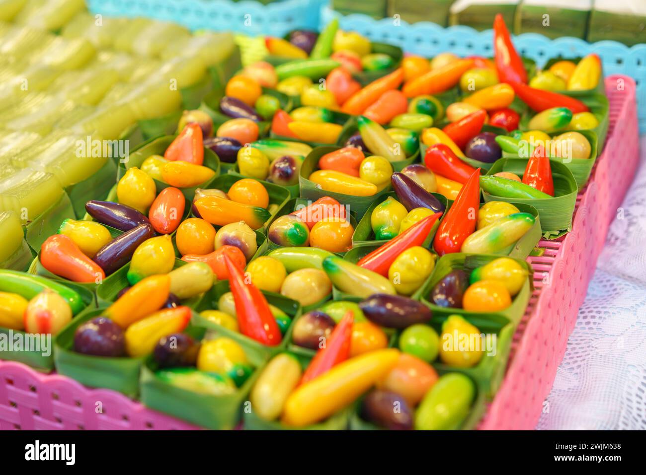 Eine Auswahl an fruchtförmigen Mung Beans lebhaften thailändischen Desserts, die an Miniatur-Obst und -Gemüse erinnern, werden in klaren Behältern im ausgestellt Stockfoto