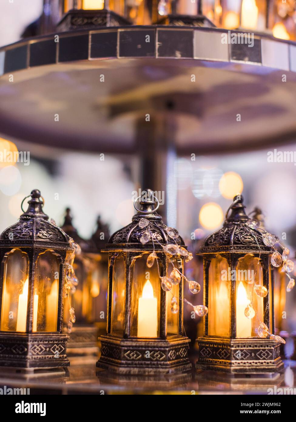 Ein Abendessen bei Kerzenschein mit einer Auswahl an Kerzen auf einem Teller, beleuchtet durch Umgebungslicht Stockfoto