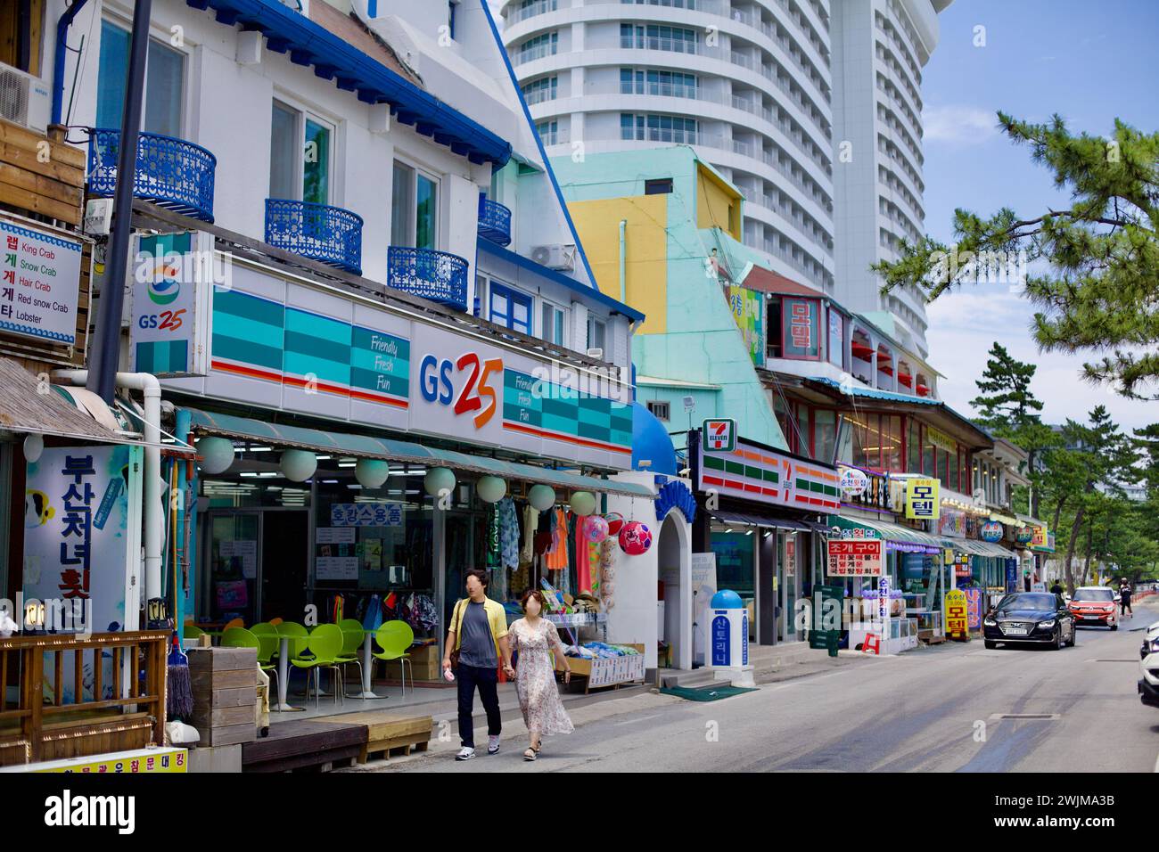 Gangneung City, Südkorea - 29. Juli 2019: Eine belebte Straße mit 24-Stunden-Geschäften und Restaurants liegt vor dem Gyeongpodae Beach, mit der majestätischen Skyba Stockfoto