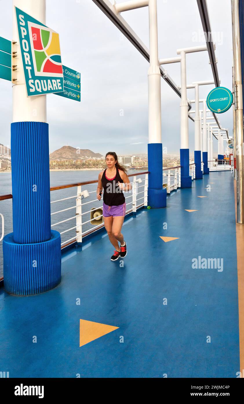 Junge Frau, die auf dem Sportplatz an Deck läuft, Kreuzfahrtschiff. Stockfoto