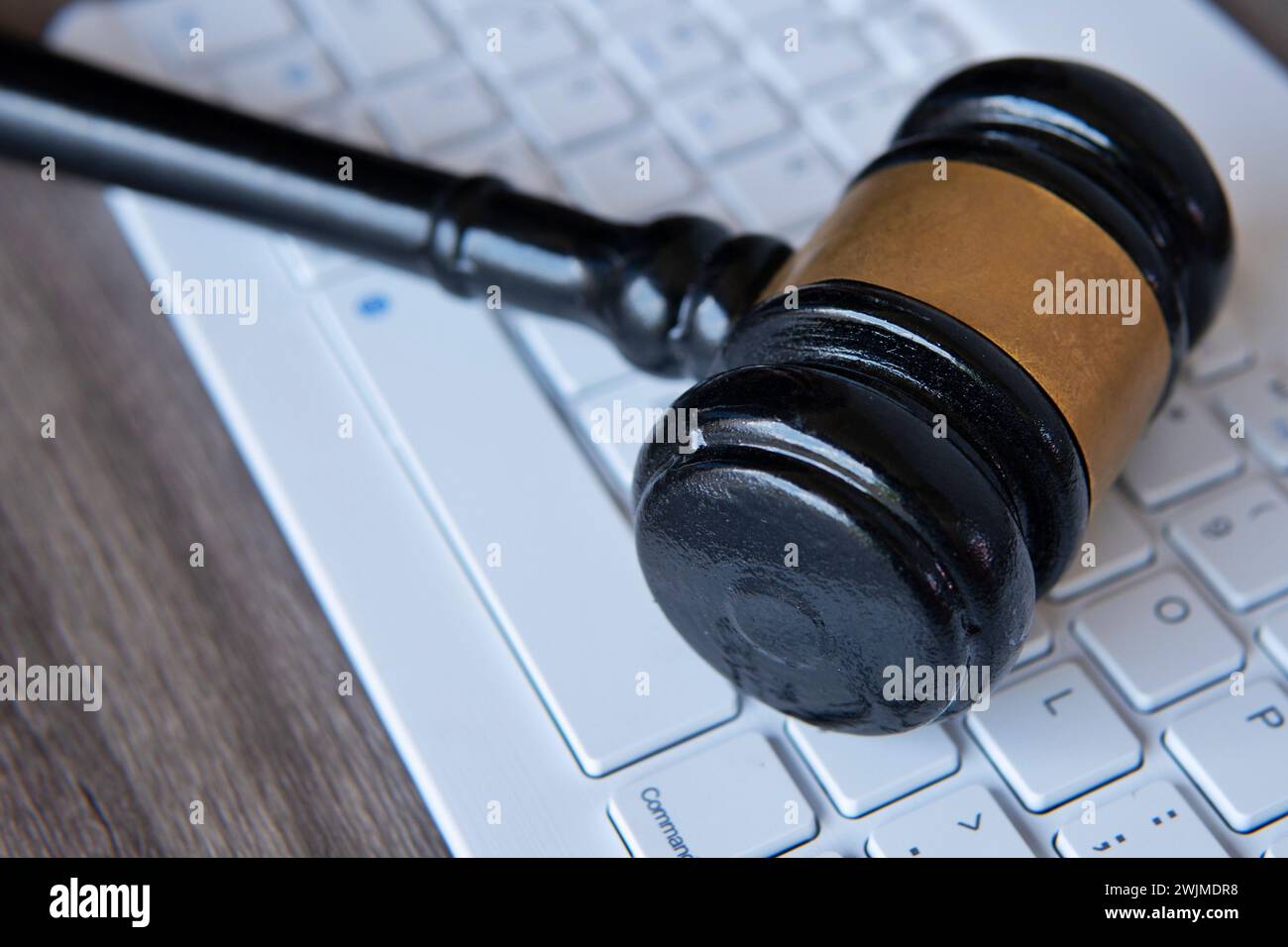 Beurteilen Sie den Hamel oben auf der weißen Tastatur. Cyberkriminalität, Recht, Recht und Online-Auktionskonzept. Stockfoto