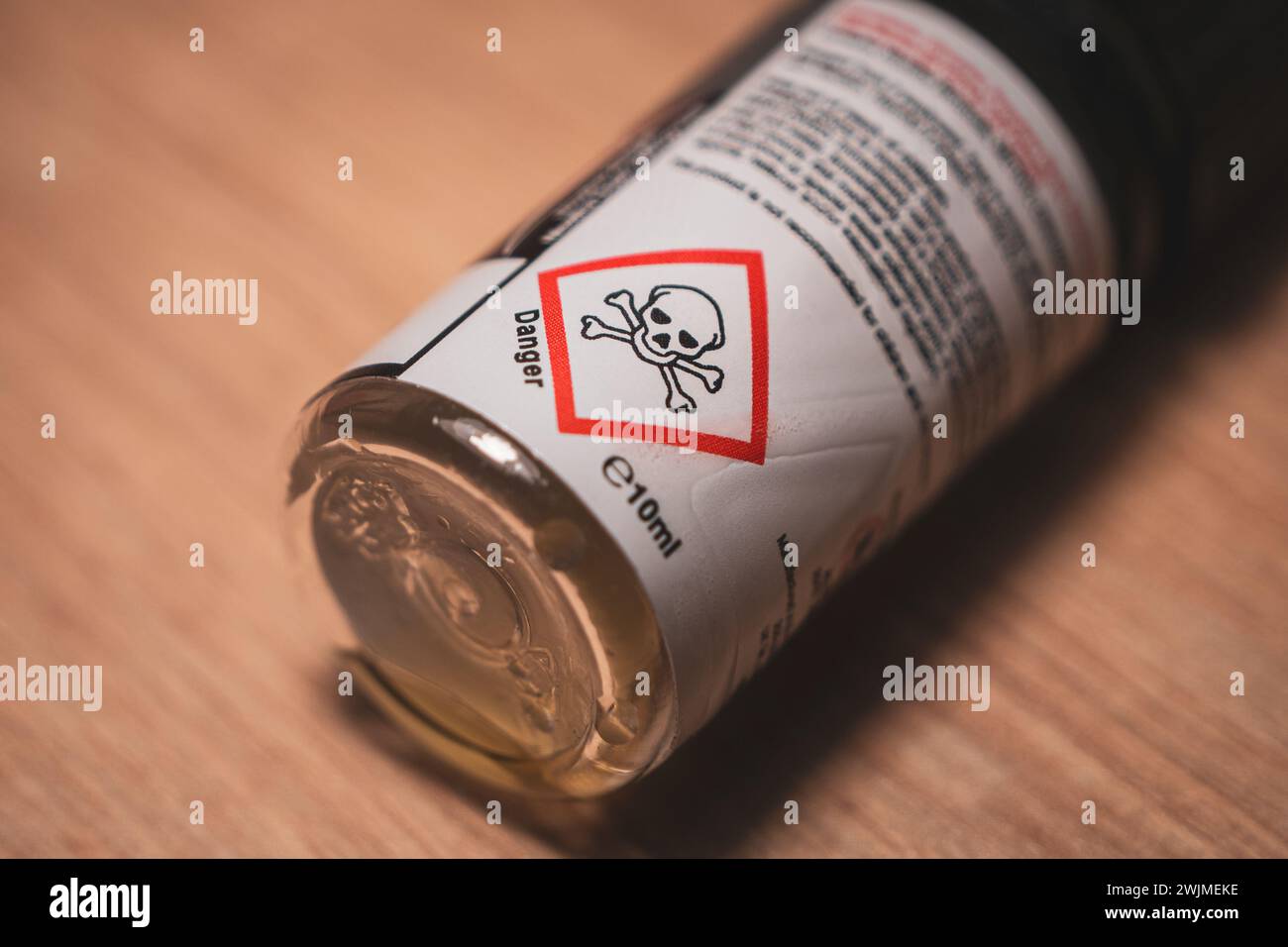 10-ml-Vape-Saftflasche mit Warnschild „Gefahr Schädel“ auf dem Etikett, Nahaufnahme mit Kopierraum. Stockfoto