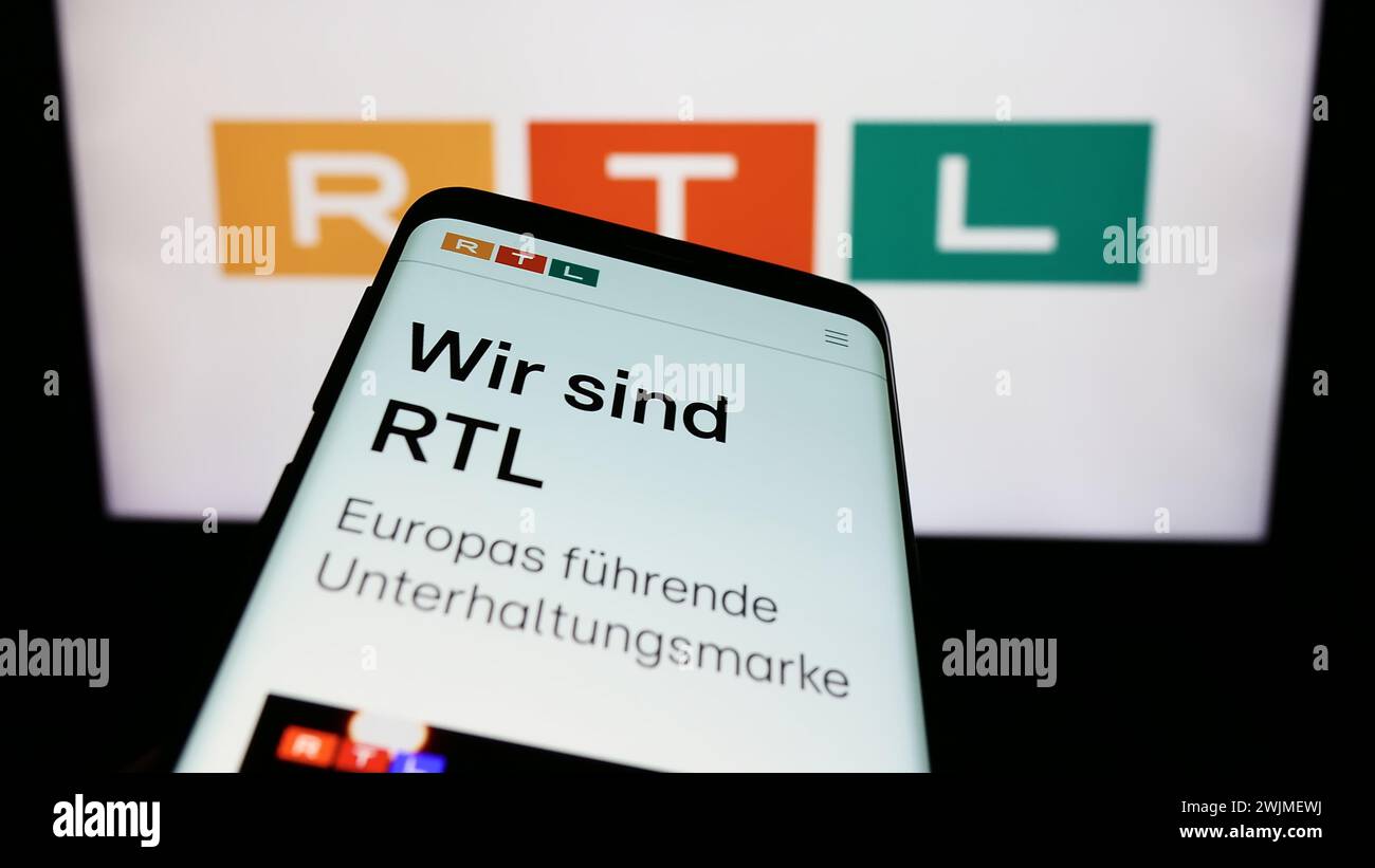 Mobiltelefon mit Webseite des Medien- und Fernsehunternehmens RTL Group S.A. vor dem Firmenlogo. Fokussieren Sie sich oben links auf der Telefonanzeige. Stockfoto