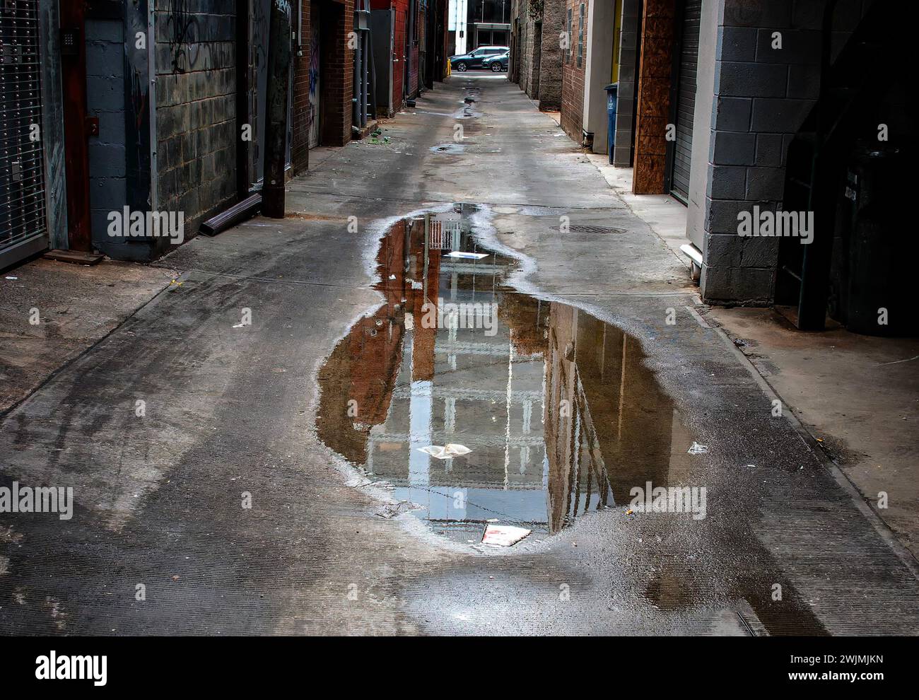 Reflexion in einem Pool mit stehendem Wasser in einer Gasse in der Innenstadt Stockfoto