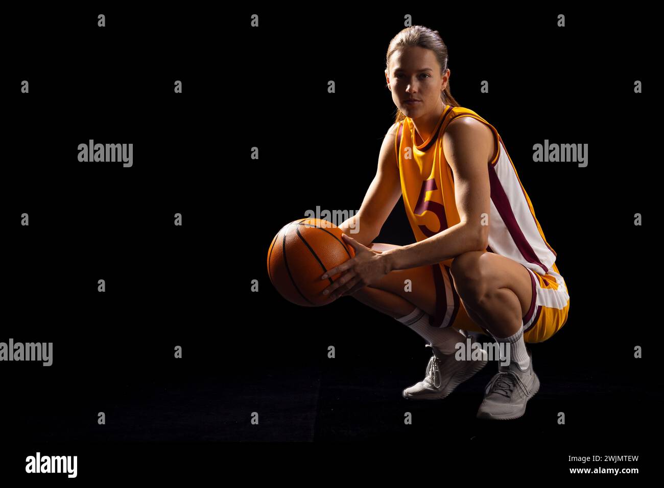 Weibliche Basketballspielerin in Pose zeigt Fokus und Leichtathletik. Stockfoto