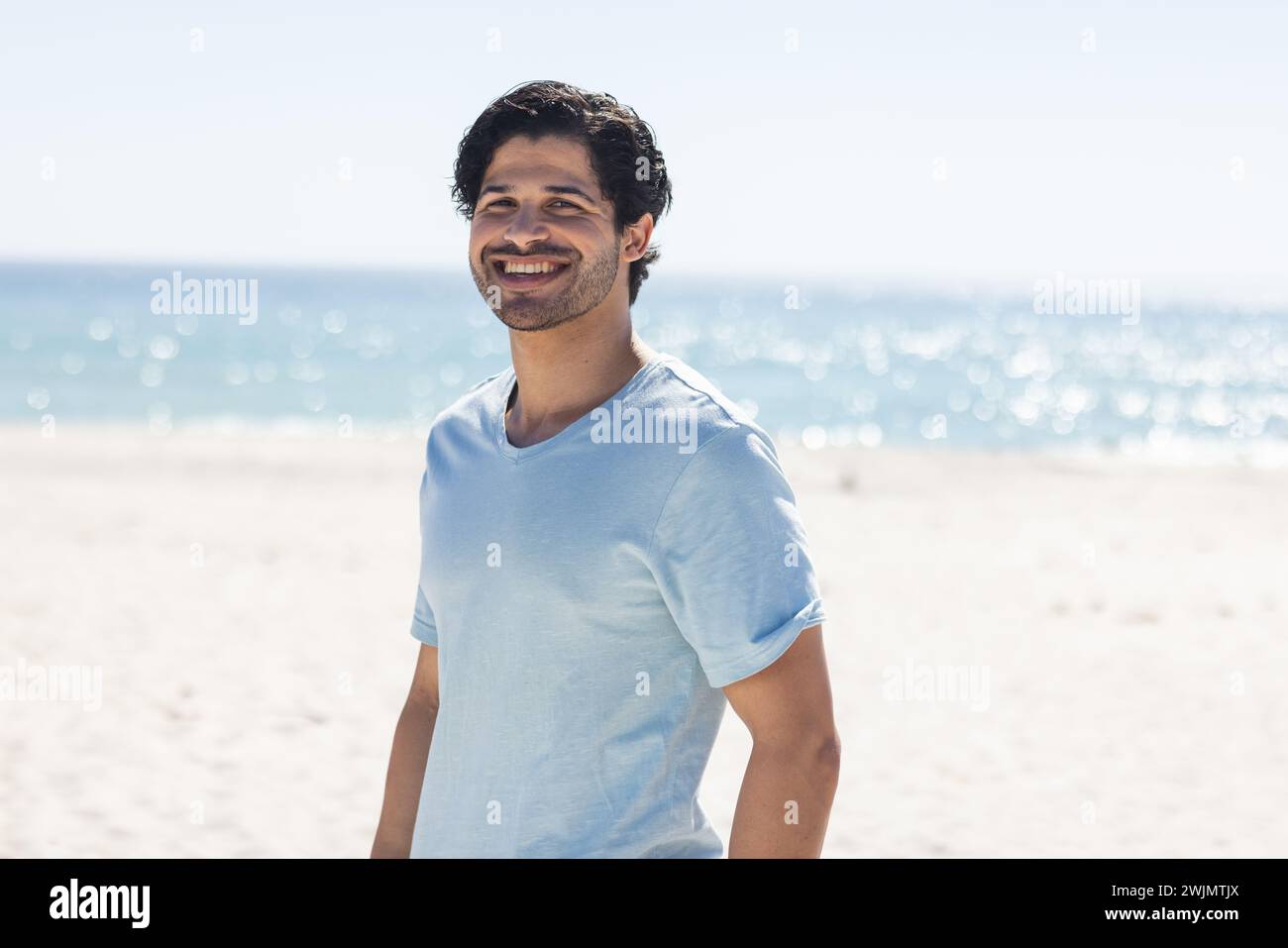 Junger Mensch mit Rasse genießt einen sonnigen Tag am Strand Stockfoto