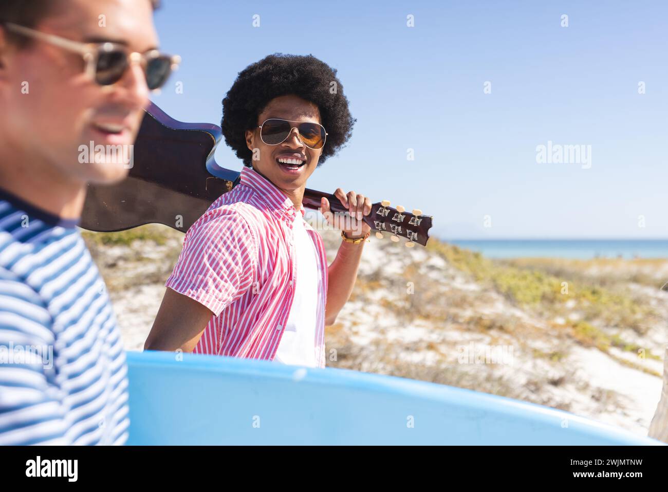 Junge Kaukasier und Afroamerikaner genießen einen sonnigen Strandtag Stockfoto