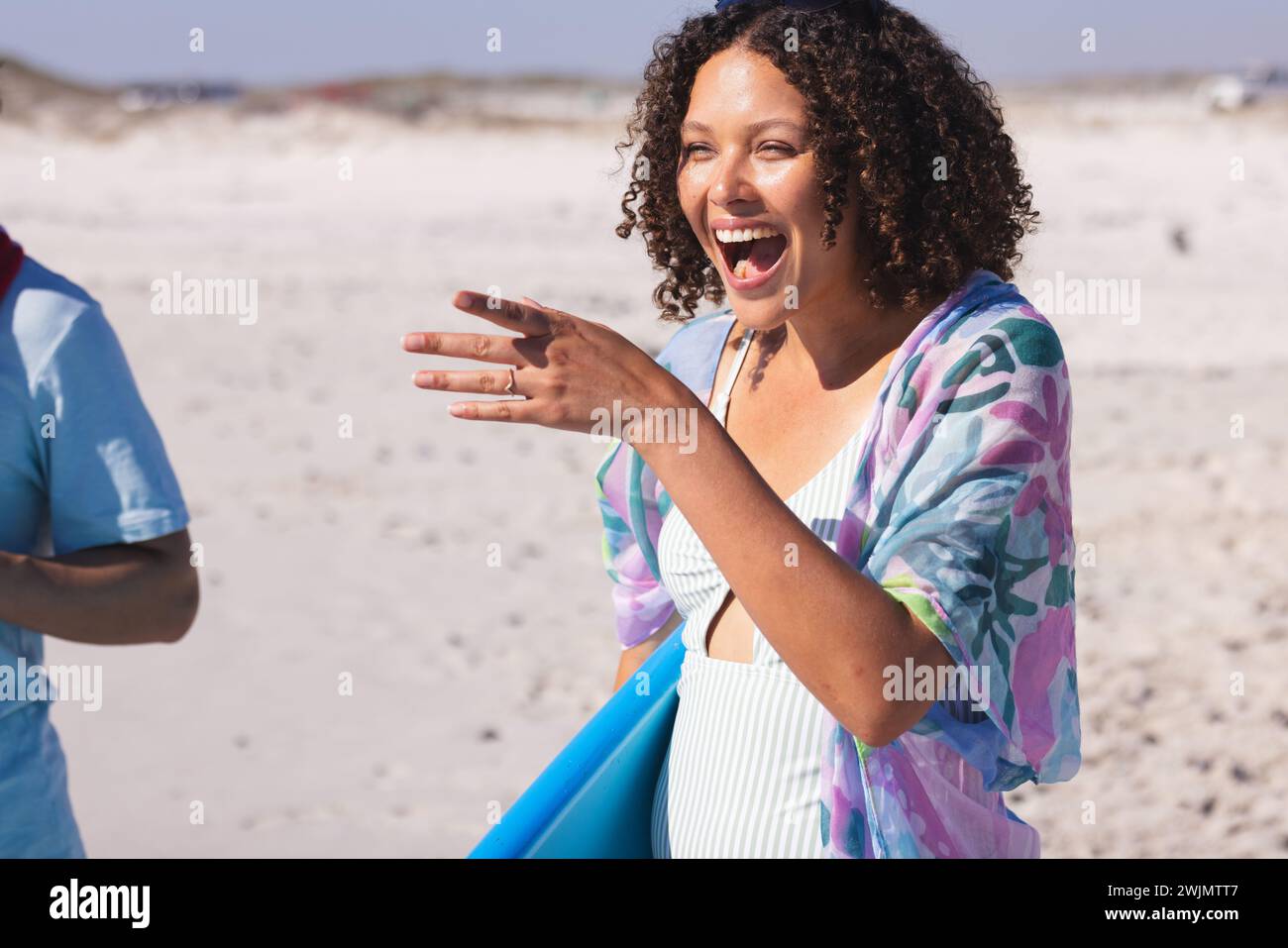 Die junge Frau lacht fröhlich am Strand Stockfoto