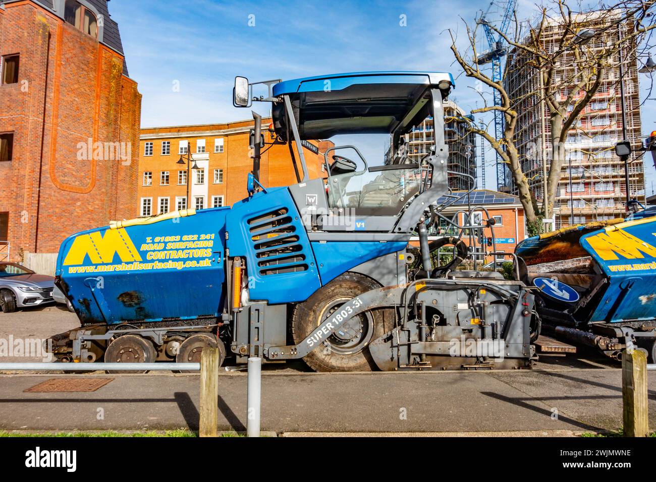 Ein Asphaltfertiger, der am Straßenrand abgestellt wird, ist ein Industriefahrzeug, das für die Verlegung neuer Straßen oder die Sanierung bestehender Straßen verwendet wird. Stockfoto