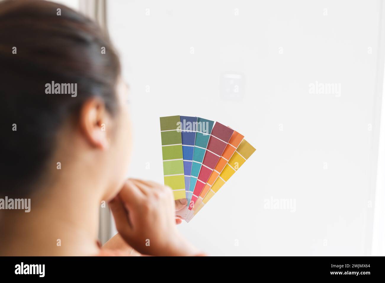 Junge birassische Frau untersucht Farbmuster zu Hause Stockfoto