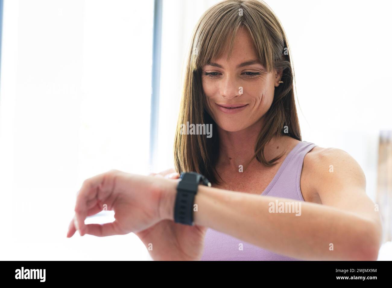 Eine weiße Frau überprüft ihren Fitness-Tracker, mit Kopierraum Stockfoto