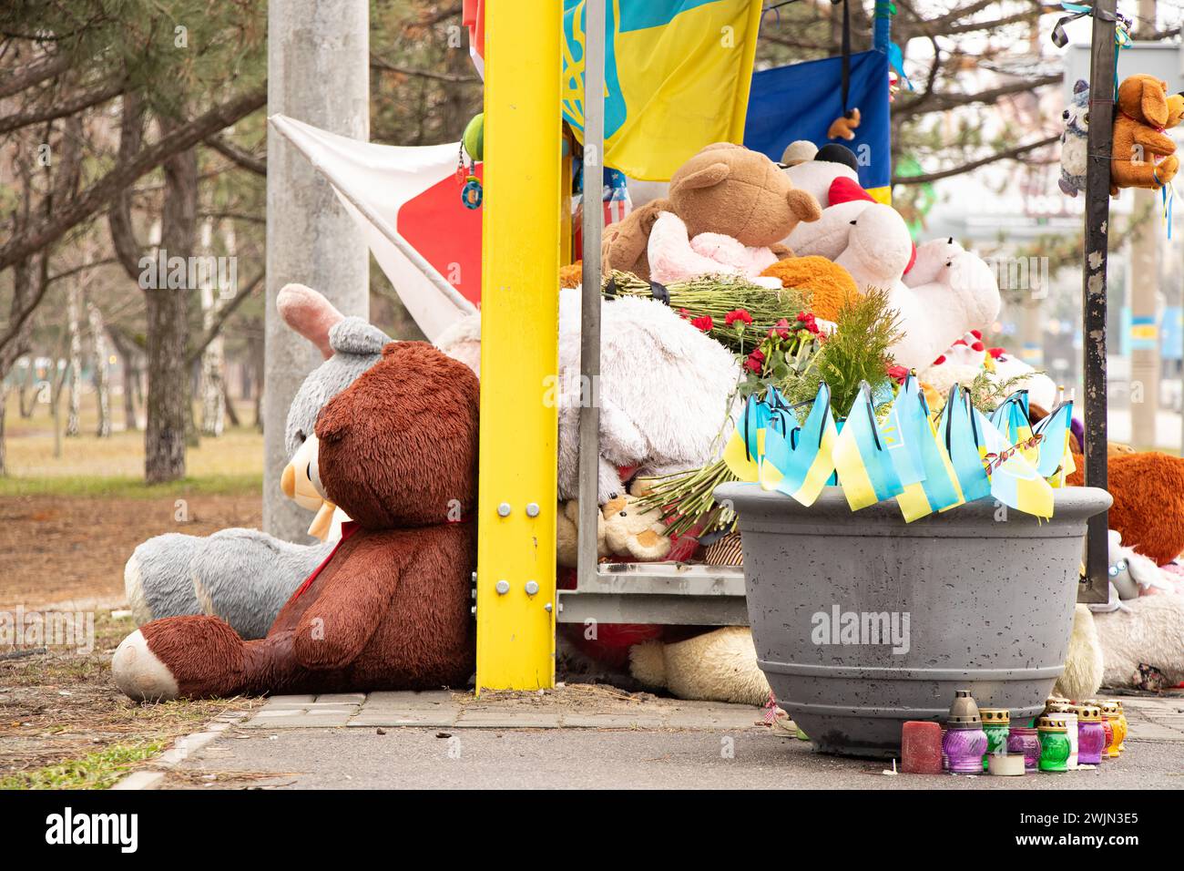 Dnipro, Ukraine, Blumen, Kinderspielzeug, Kerzen, ein Ort der Erinnerung in der Nähe eines Wohngebäudes an einer Bushaltestelle, zerstört von einer russischen Rakete, der f Stockfoto