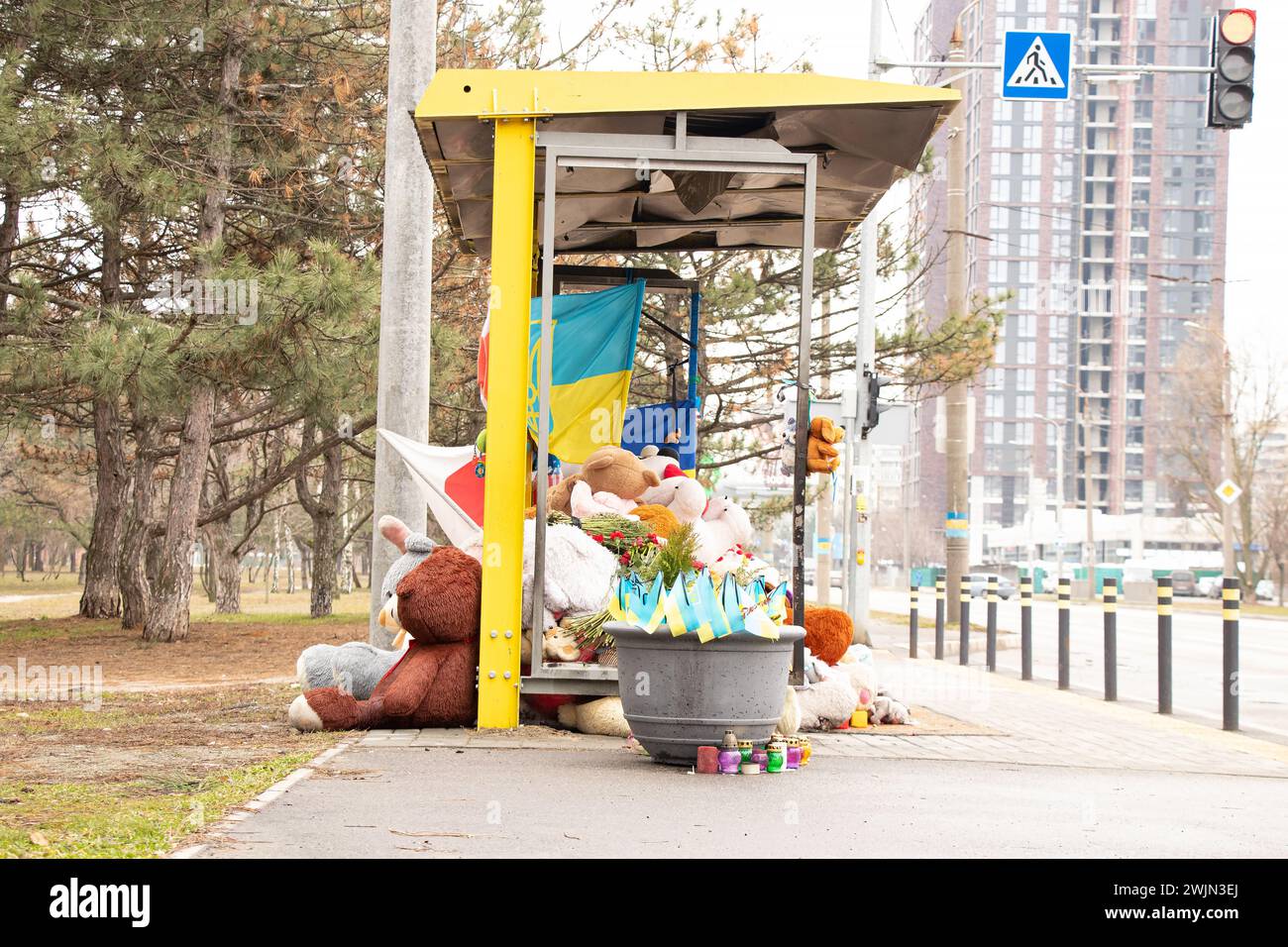 Dnipro, Ukraine, Blumen, Kinderspielzeug, Kerzen, ein Ort der Erinnerung in der Nähe eines Wohngebäudes an einer Bushaltestelle, zerstört von einer russischen Rakete, der f Stockfoto