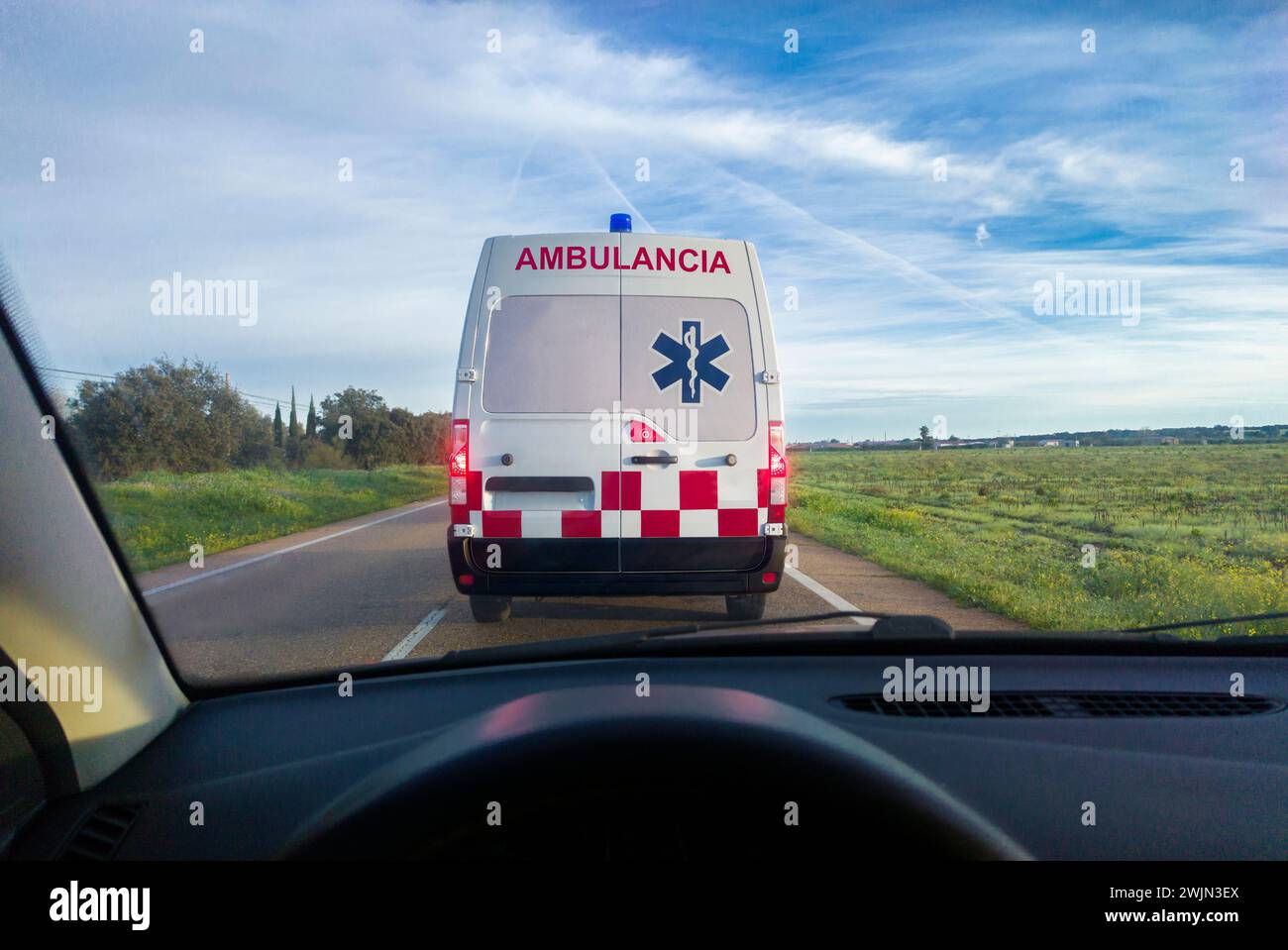 Hinter einem Krankenwagen auf der örtlichen Straße fahren. Blick von der Innenseite des Autos. Blick von der Innenseite des Autos Stockfoto