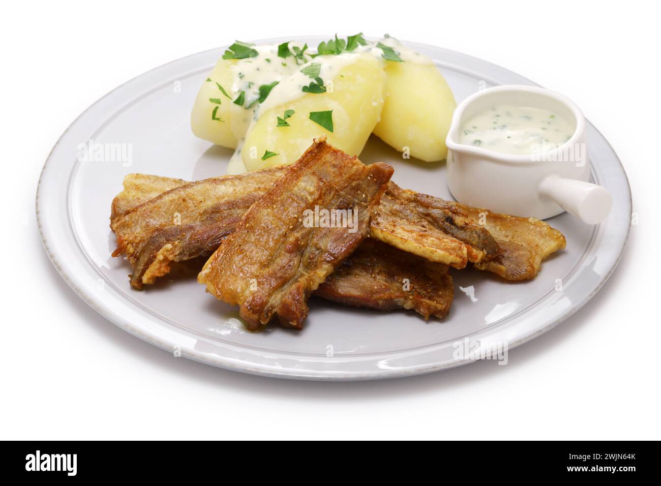 "Stegt flæsk med persillesovs" (Schweinebauch in Scheiben mit Haut und gebraten, serviert mit Petersiliensauce und gekochten Kartoffeln). Dänemarks Nationalkost. Stockfoto