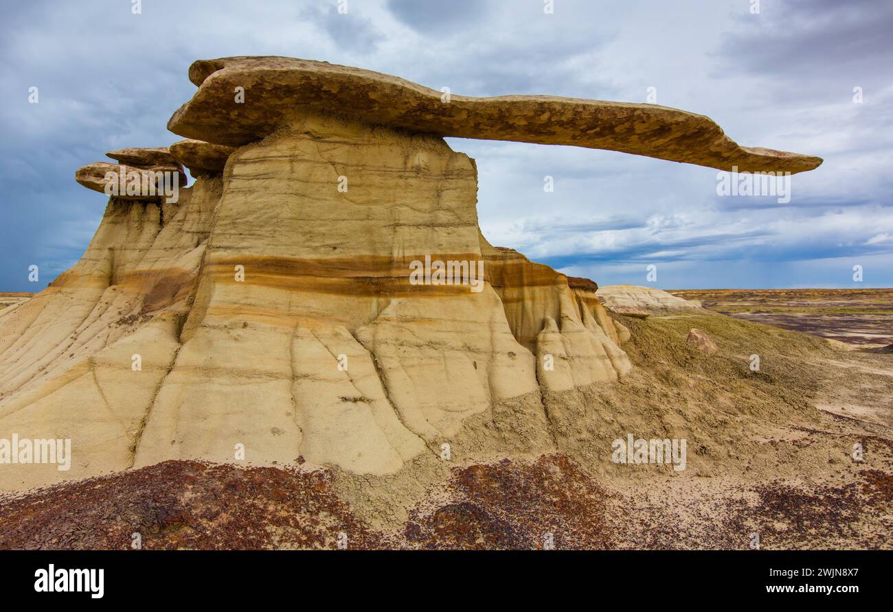 Der King of Wings, ein sehr zerbrechlicher Sandstein-Hoodoo in den Badlands des San Juan Basin in New Mexico, mit Sturmwolken dahinter. Stockfoto