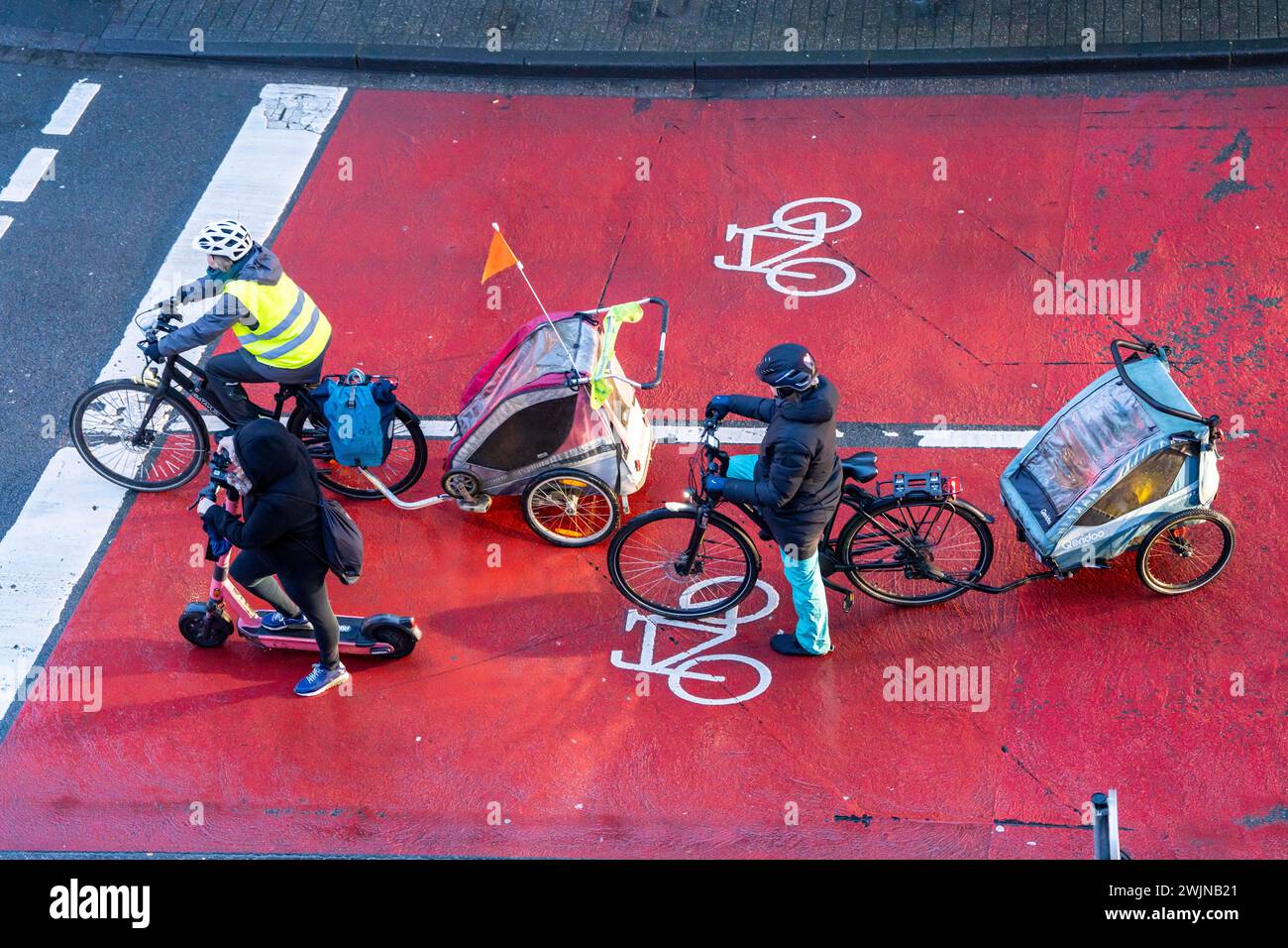 E-Scooter, E-Scooter auf Fahrradweg, Parkplatz für Radfahrer an einer Ampelkreuzung, rot markiert, Autos, LKW müssen hinter ihm bei rot halten Stockfoto