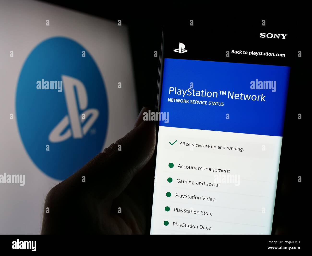 Person, die ein Mobiltelefon hält, mit der Webseite der Videospielplattform PlayStation Network (PSN) vor dem Logo. Konzentrieren Sie sich auf die Mitte des Telefondisplays. Stockfoto