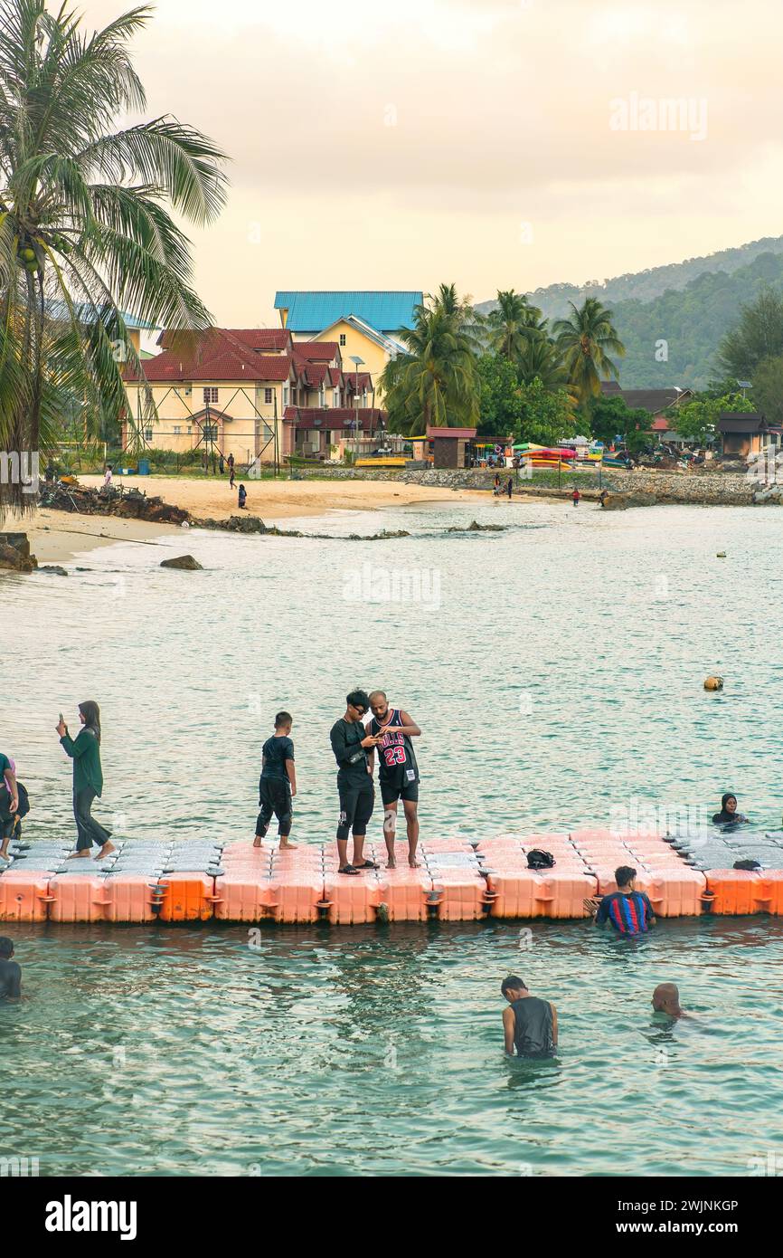 Eine Gruppe von Menschen hat Spaß auf der schwimmenden Brücke auf der Insel Perhentian Stockfoto