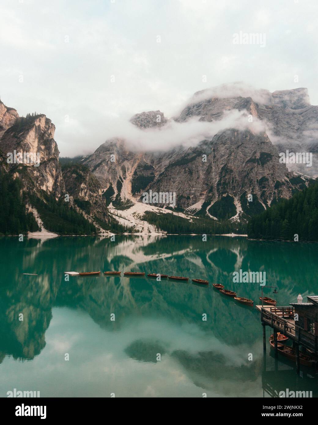 Ein majestätischer See, eingebettet in hoch aufragende Berge, geschmückt mit einem wunderschönen Vorboden von üppigen Bäumen Stockfoto