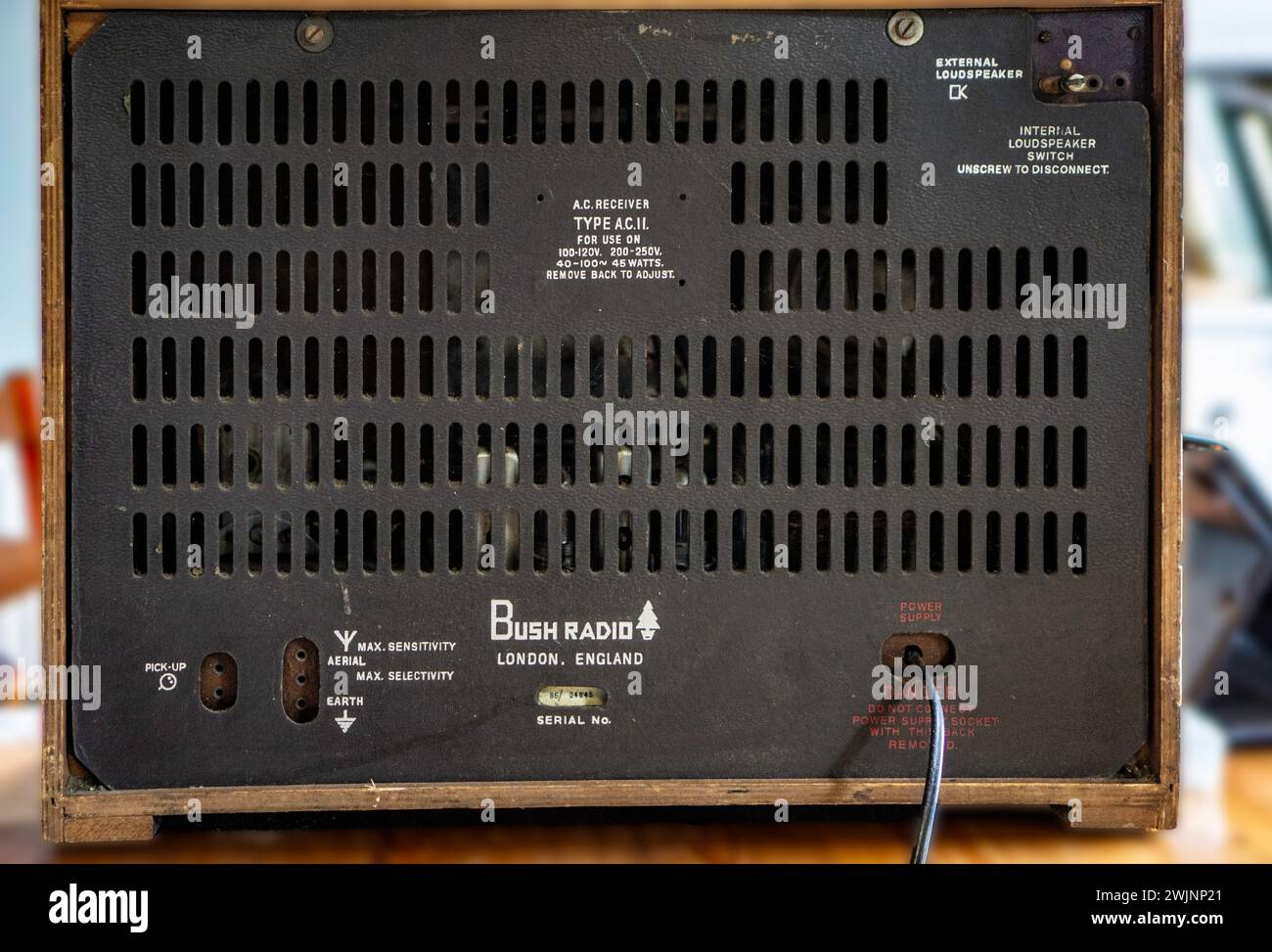 Die Rückseite eines alten Radios mit Buchsenventilen, das Informationen zu den technischen Daten des Geräts enthält. Der 1932 gegründete Markenname Bush stammt von seiner Adresse in Shepards Bush, London, England. Der Markenname ist erhalten geblieben und hat mehrmals den Besitzer gewechselt. Es ist weiterhin möglich, Ersatzteile einschließlich Ventile für diese Funkgeräte zu kaufen. Die Produktion von Valve Radio wurde in den 1960er Jahren mit der Einführung von Transistorradios eingestellt. Stockfoto