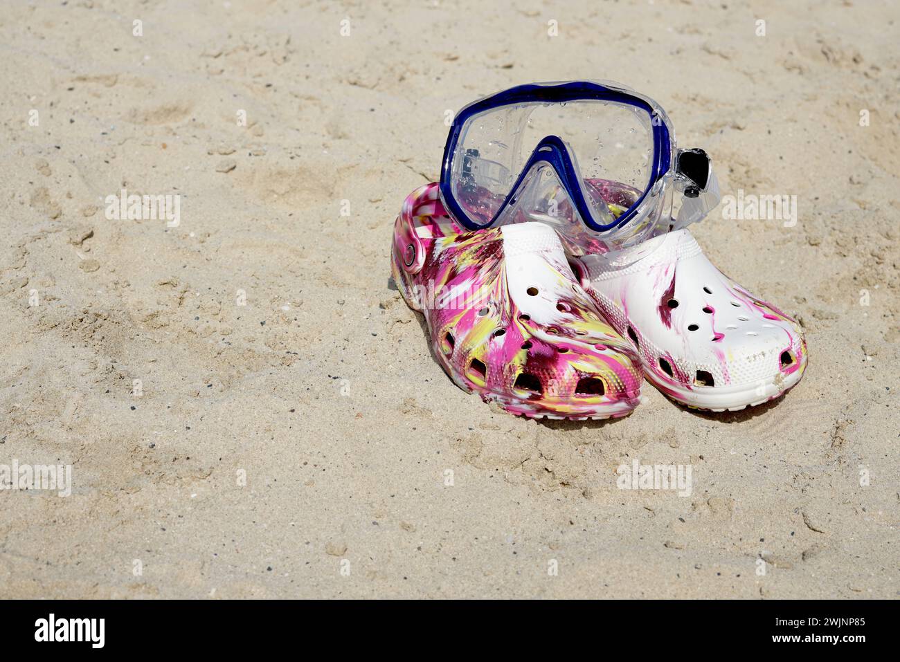 Stilvolle Flips Flops mit Schnorchelmaske auf Sand Stockfoto