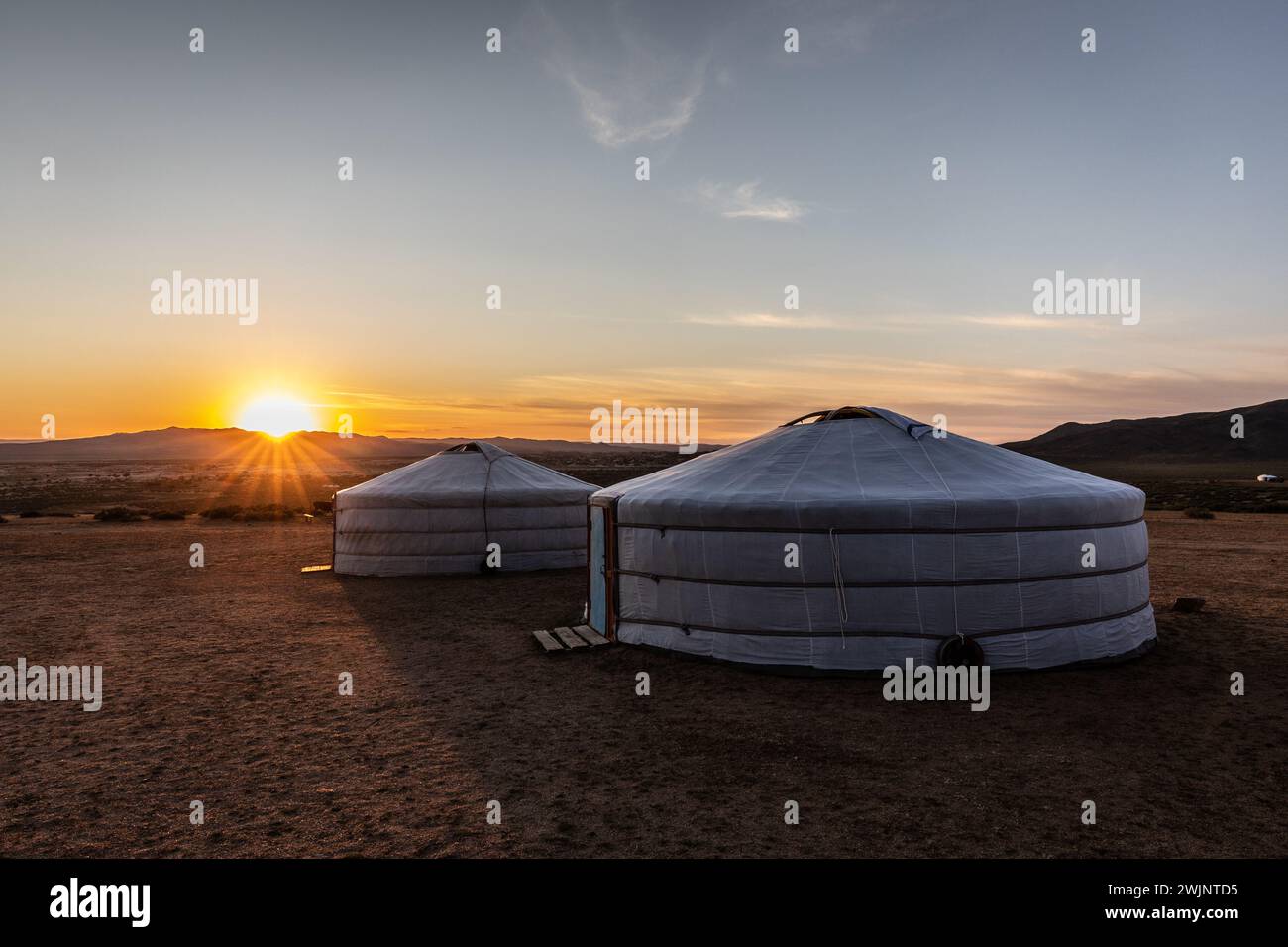 Die Morgensonne taucht zwei Jurten in der zentralen Mongolei in ein Morgenglühen. Stockfoto