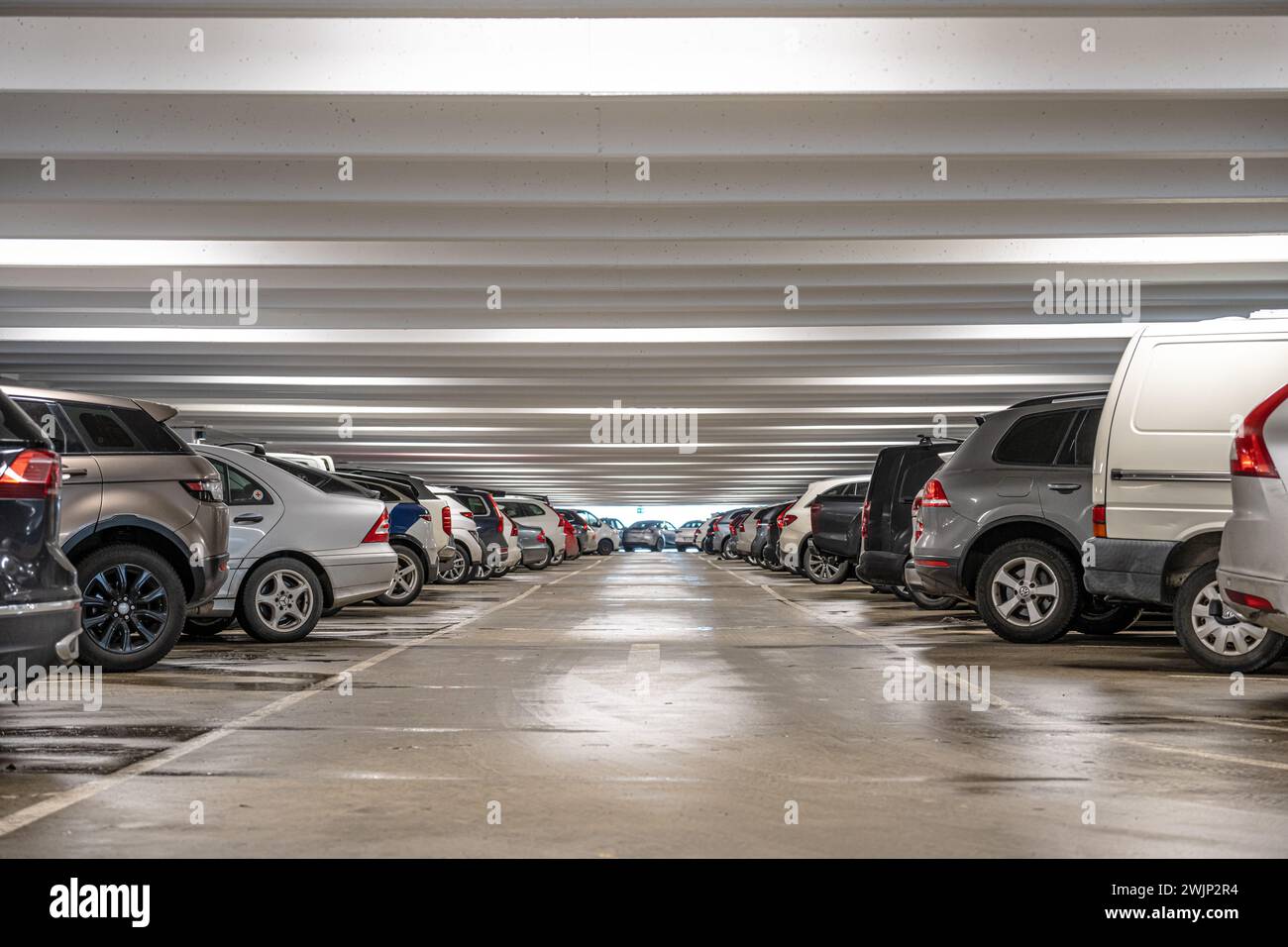 Göteborg, Schweden - 11. Februar 2024: Lange Reihe monochromer Autos in einem Parkhaus Stockfoto