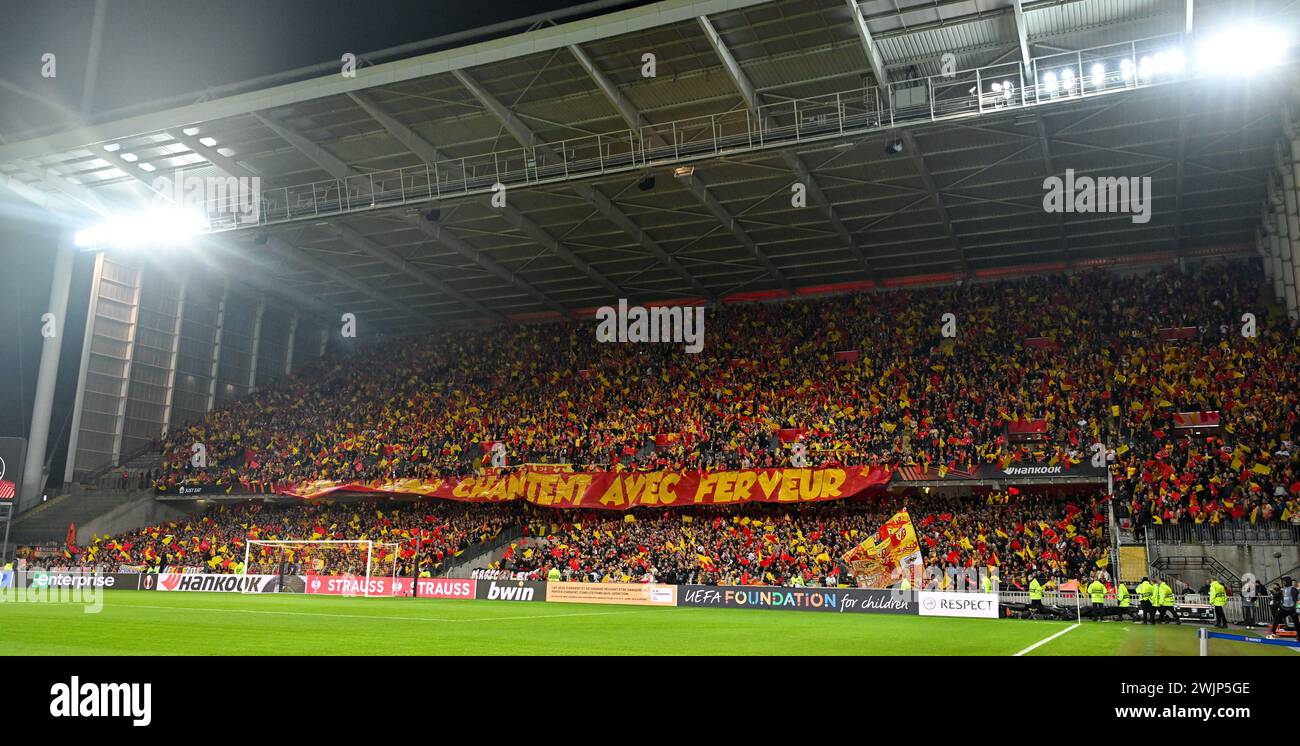 Linse, Frankreich. Februar 2024. Fans und Fans von Lens in der Tribüne Delacourt steht mit dem Banner Chantent avec Inbrunst und winkt mit roten und gelben Fahnen vor dem Play-off der UEFA Europa League - das erste Legspiel in der Saison 2023-2024 zwischen Racing Club de Lens und SC Freiburg am 15. Februar, 2024 in Lens, Frankreich. (Foto: David Catry/Isosport) Credit: Sportpix/Alamy Live News Stockfoto